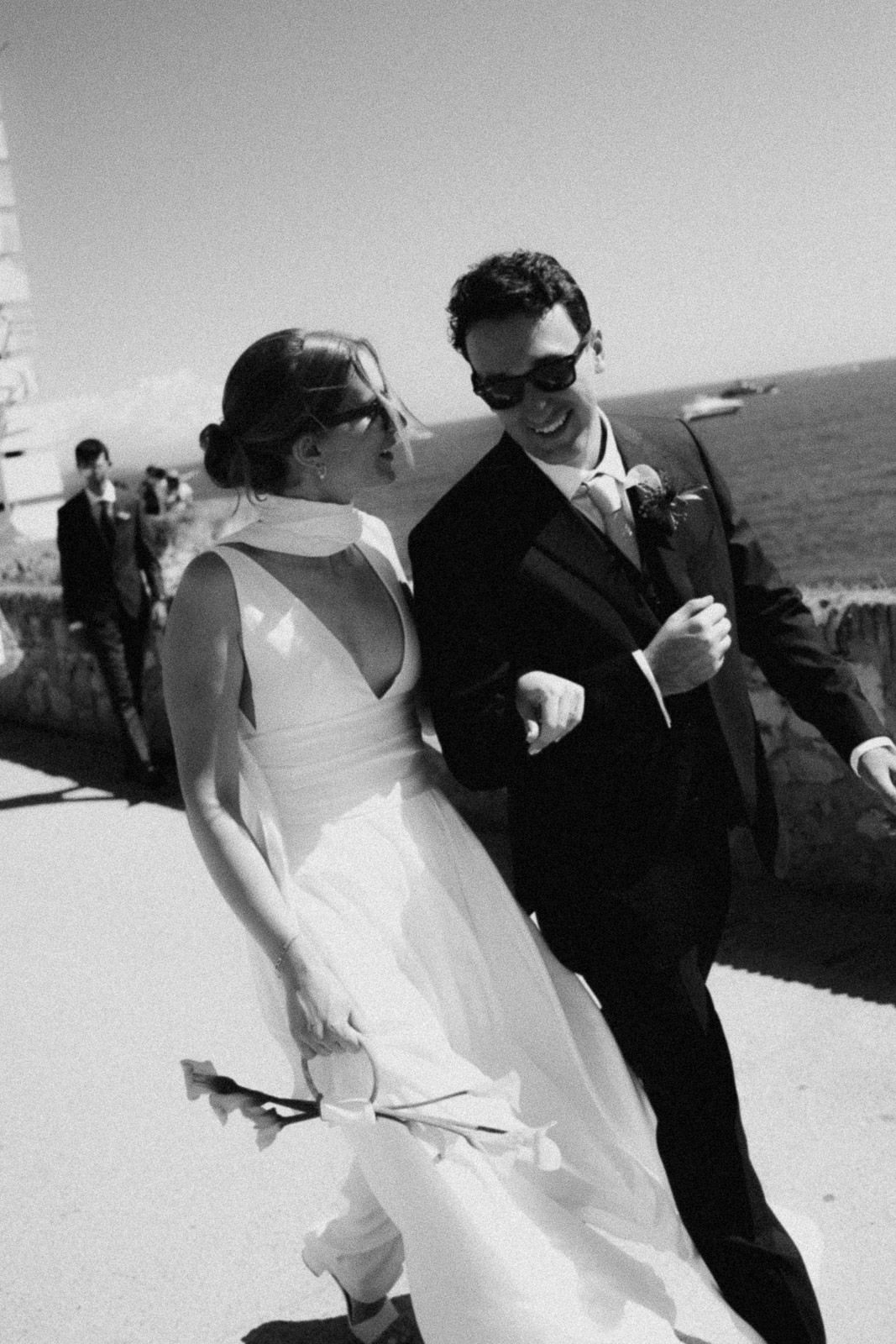 A sequence of black and white wedding photos showing a couple by the ocean in formal attire.