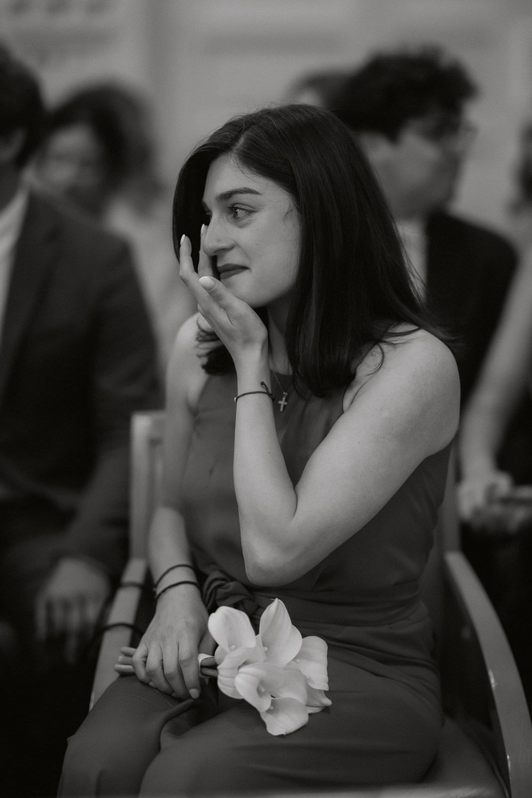 A sequence of black and white photos showing emotional reactions at what appears to be a wedding or formal event.