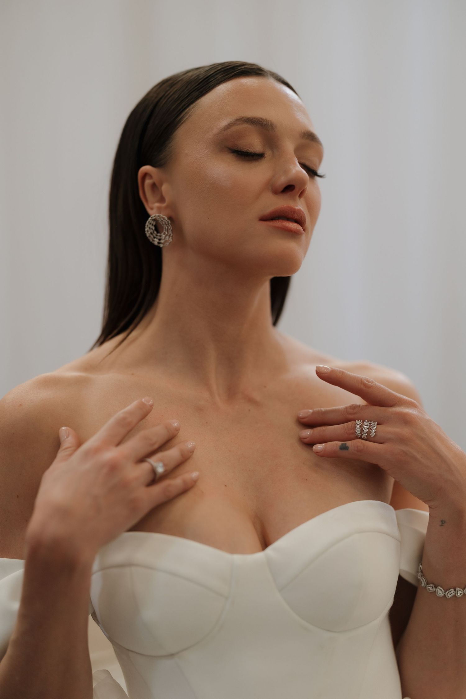 Close-up portrait series showing elegant jewelry and a white strapless dress in multiple poses.