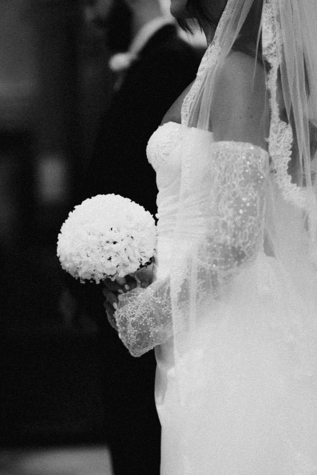 A series of black and white wedding photos showing a bride in a lace dress holding a white hydrangea bouquet.