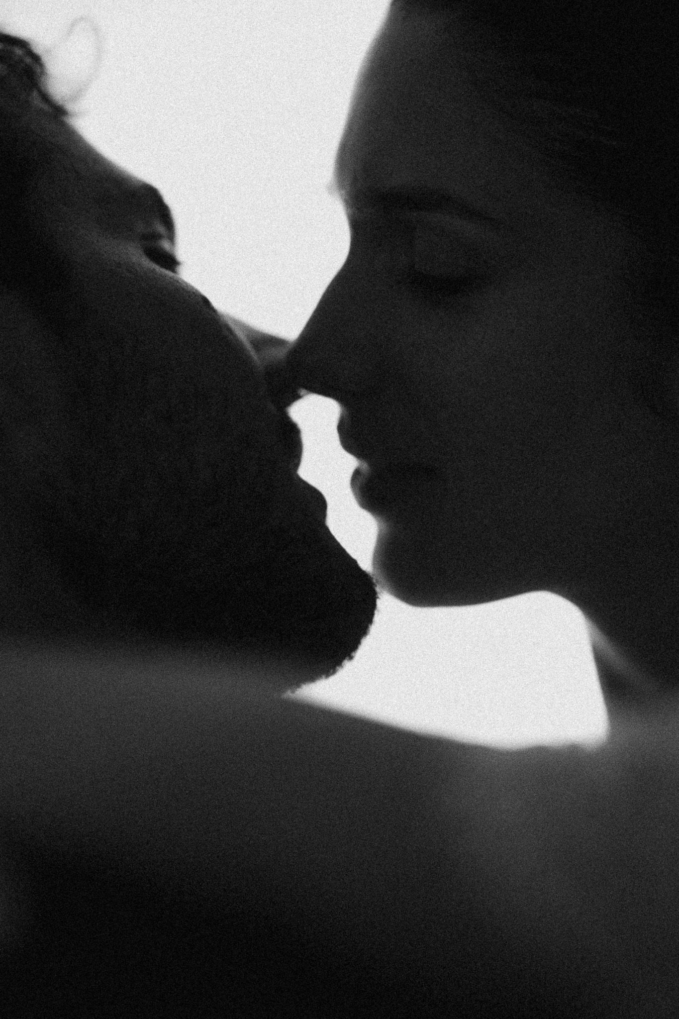 Intimate black and white close-up of a couple about to share a romantic kiss.