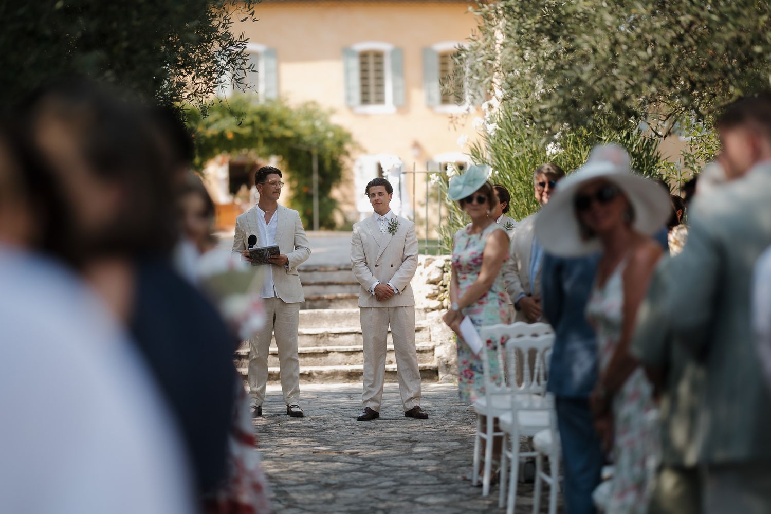 Groom waiting at the altar during an outdoor wedding ceremony at a rustic French villa.