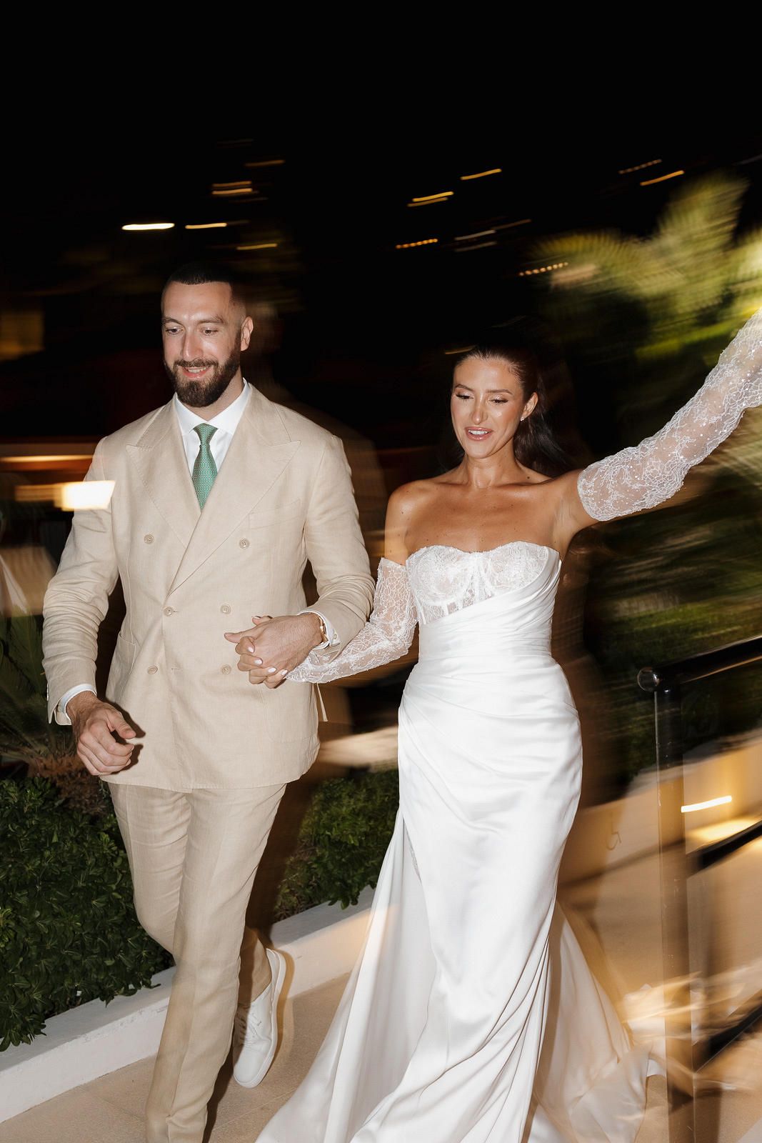 A couple in wedding attire dances together during their reception, creating a joyful motion blur effect.