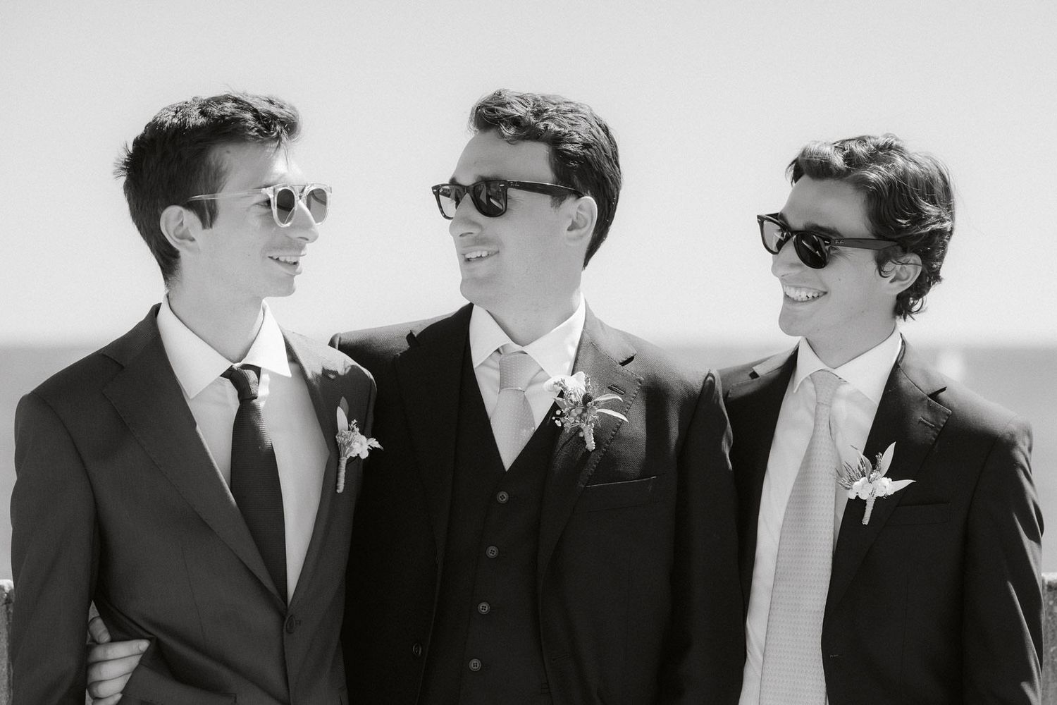Group of men in dark suits and sunglasses walking together in a vintage black and white photograph.