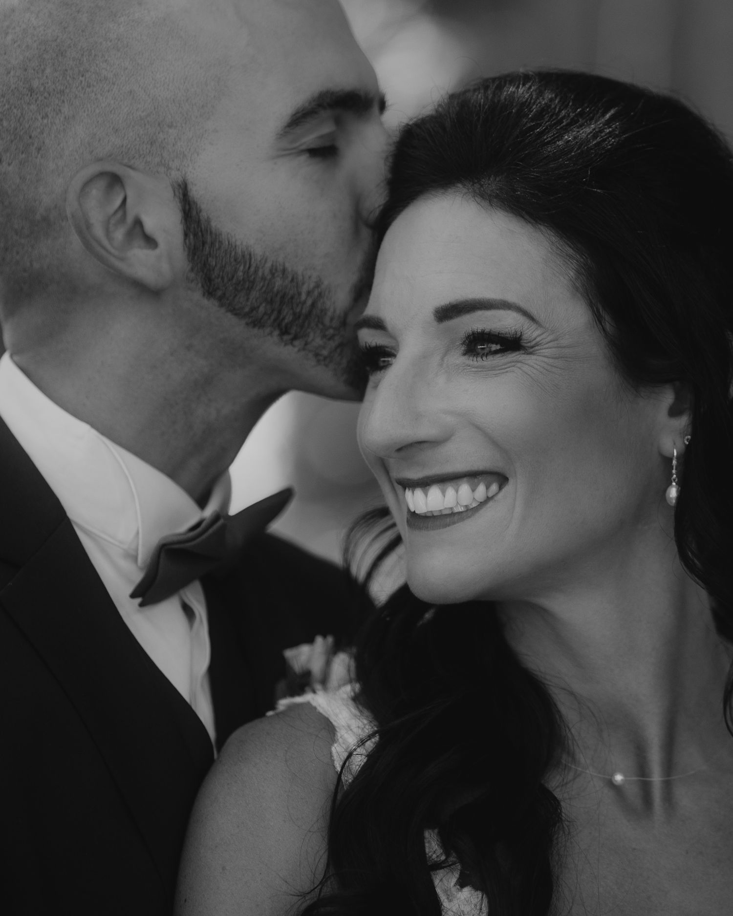 An intimate black and white wedding portrait capturing a tender moment.