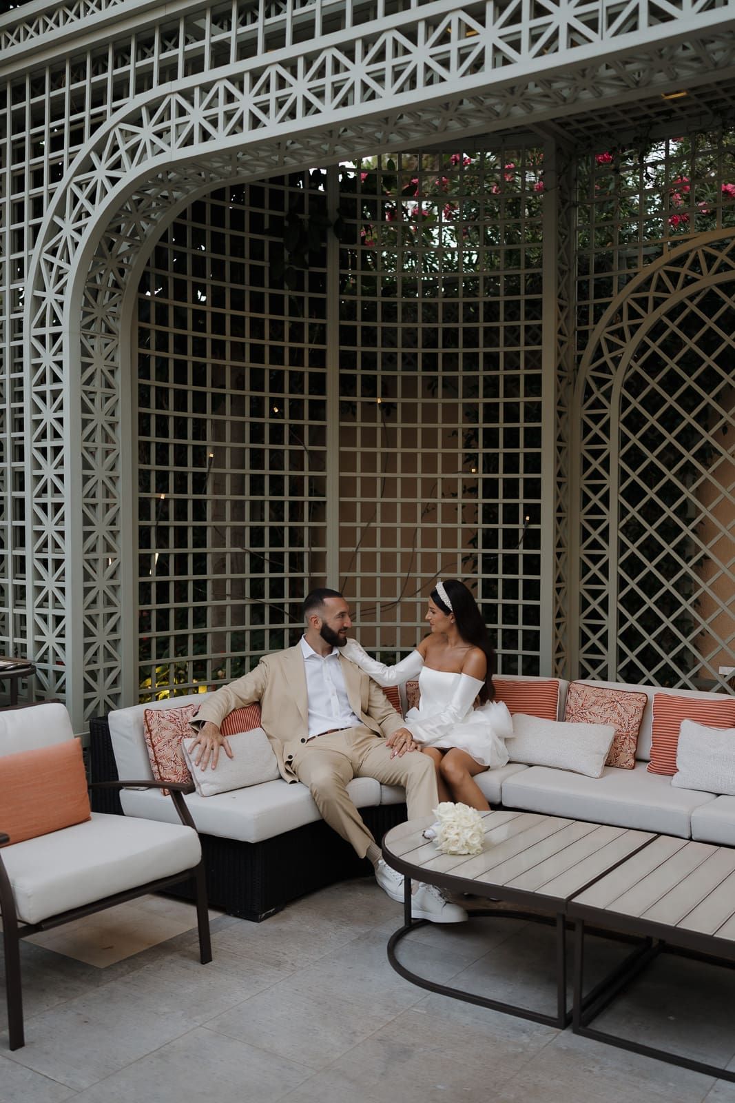 A series of photos showing a couple lounging on outdoor furniture beneath an ornate white lattice gazebo structure.