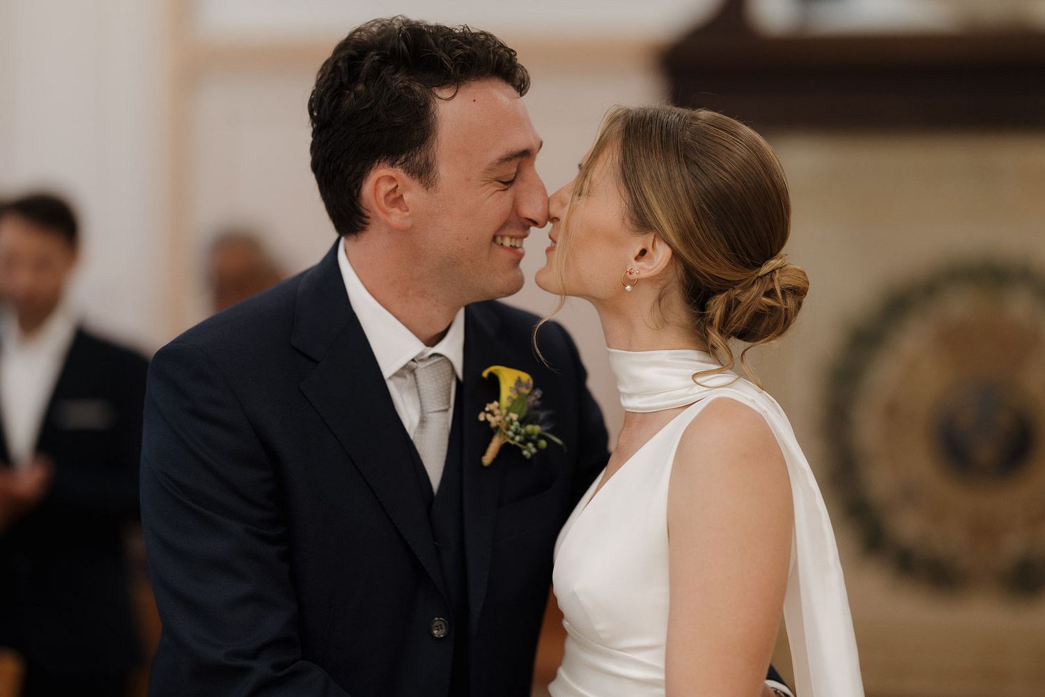 A romantic moment captured during a wedding celebration with elegant decor in the background.