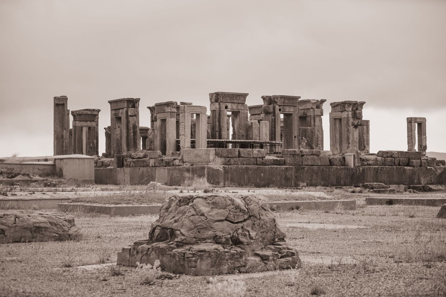 Ruins of Persepolis showing ancient stone columns and structures against a desert landscape.