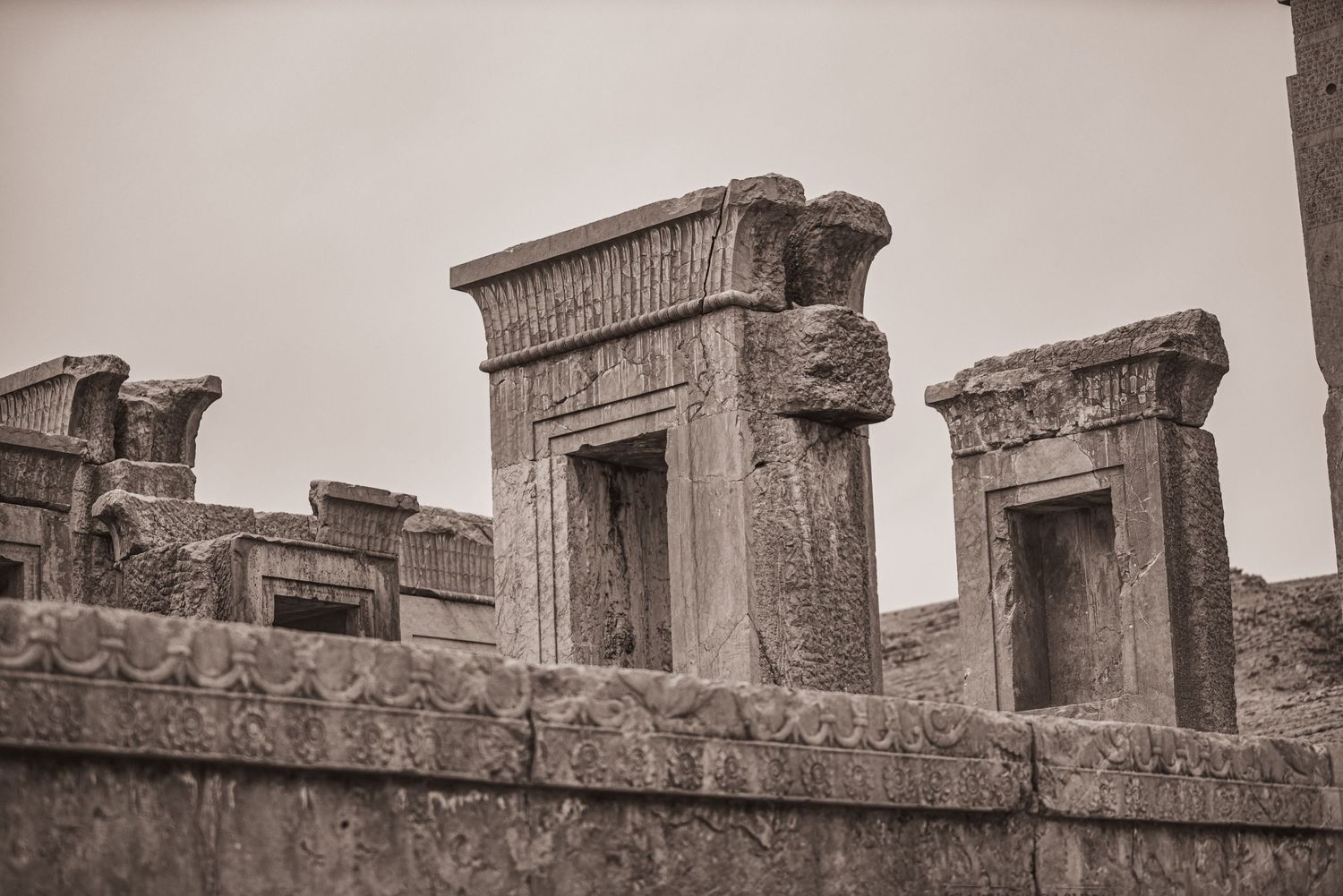 Detailed architectural elements of ancient Persian doorways with ornate carvings and decorative stonework.