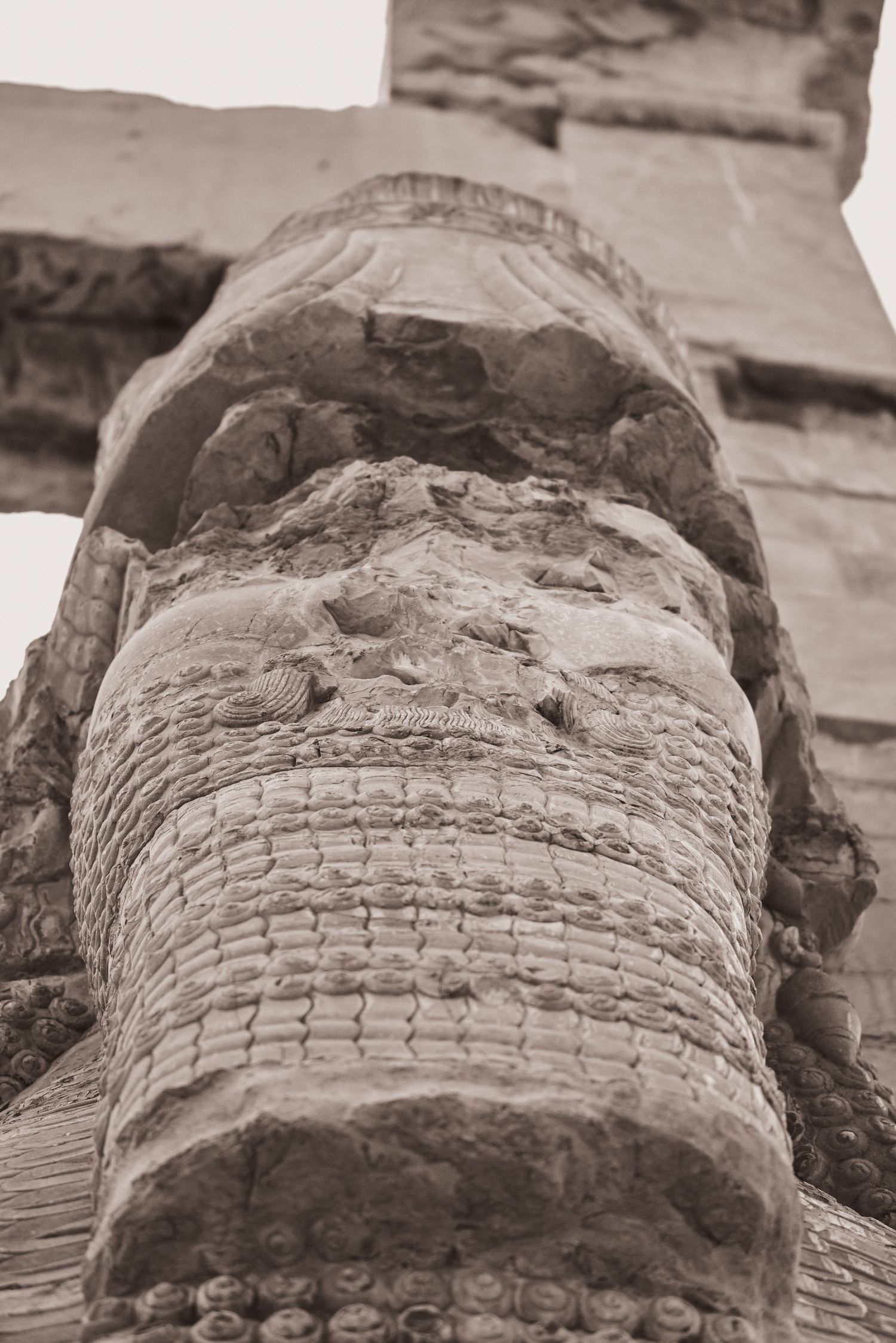 Close-up detail of weathered stone carving showing intricate patterns and textures.