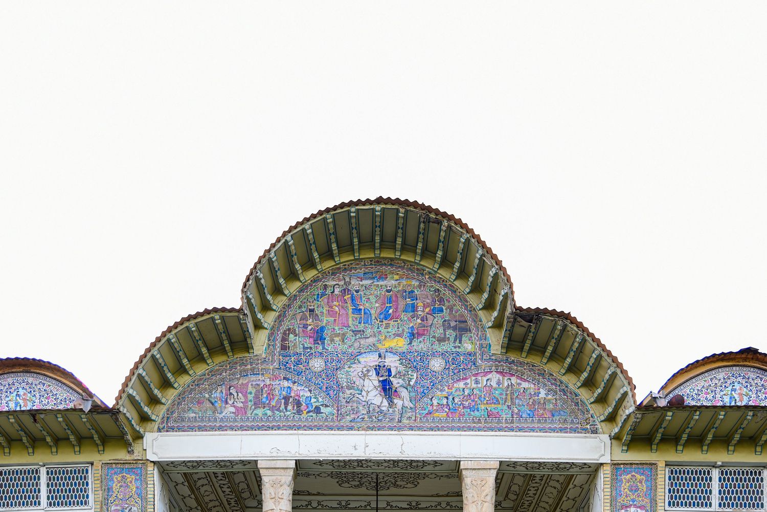 Decorative arched entrance with mosaic tilework and green domed roof details.