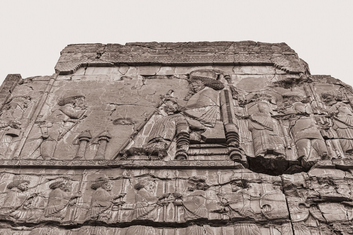 Ancient stone relief panel showing ceremonial or royal scenes from Persian history.