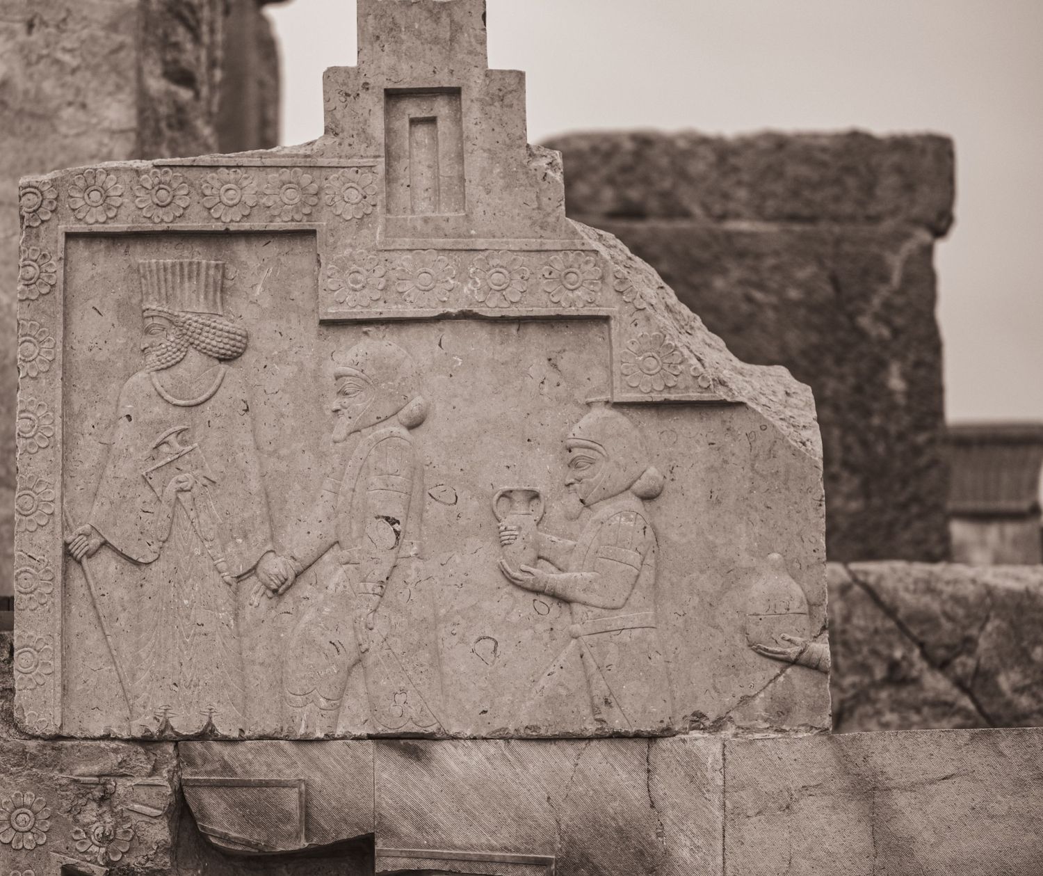 Stone relief panel showing figures in procession from ancient Persian civilization.