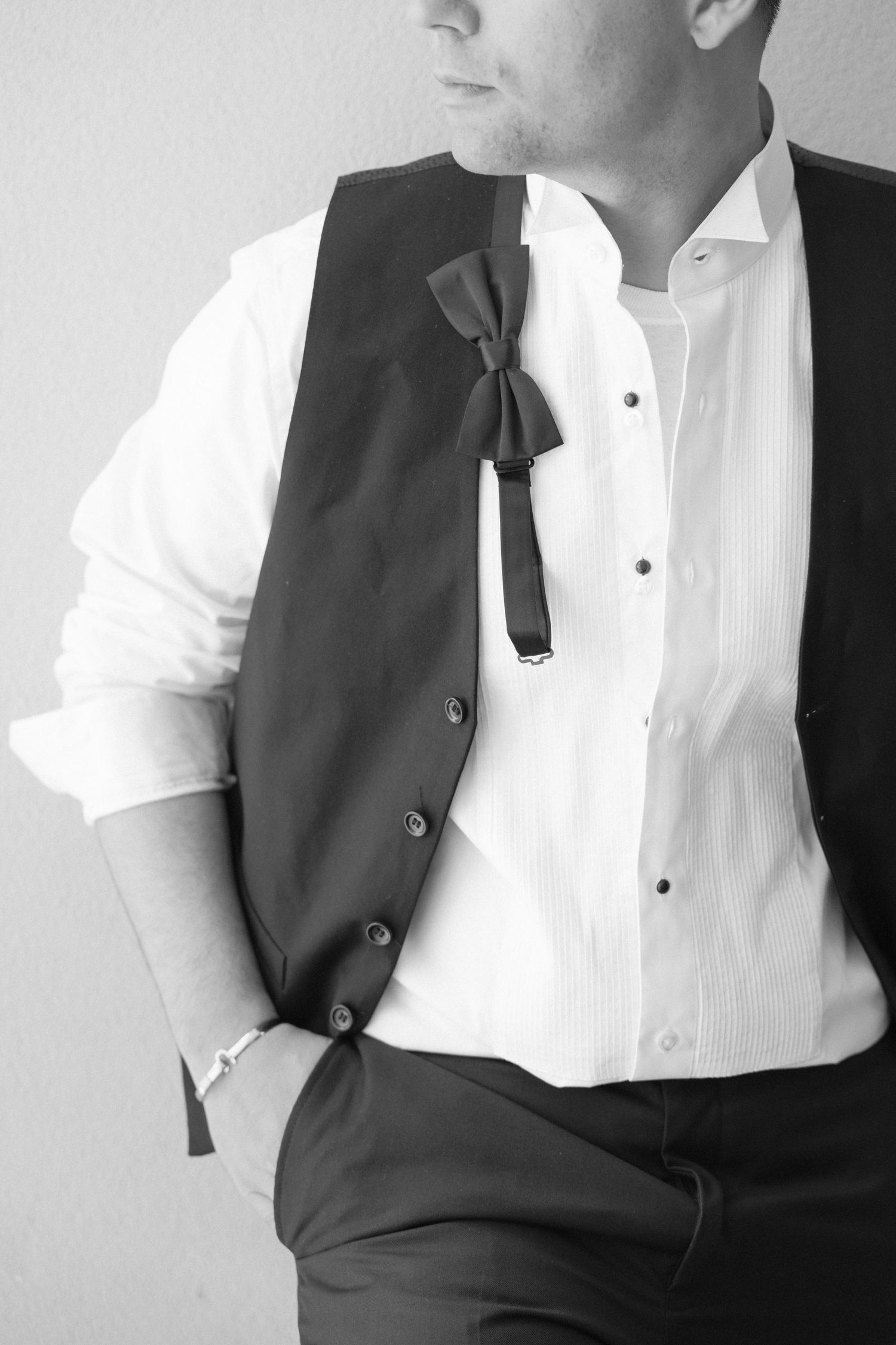 Formal attire details showing white shirt and black vest in classic black and white style.