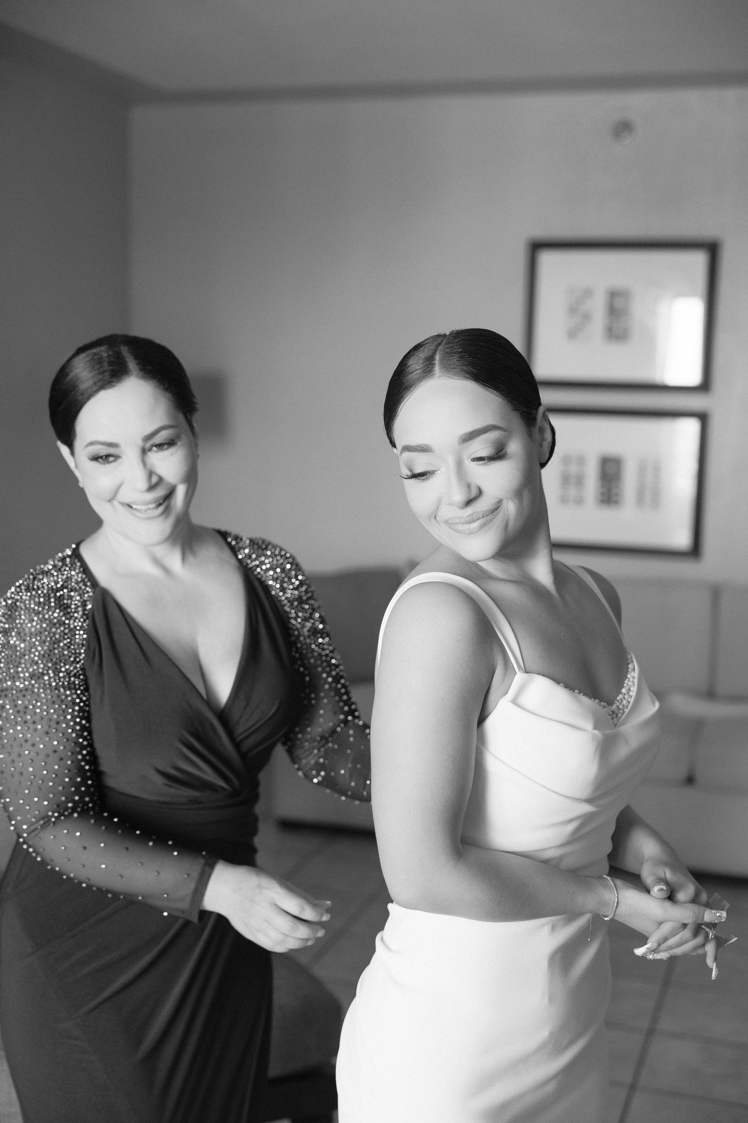 Candid moments of wedding dress preparation with attendant helping.