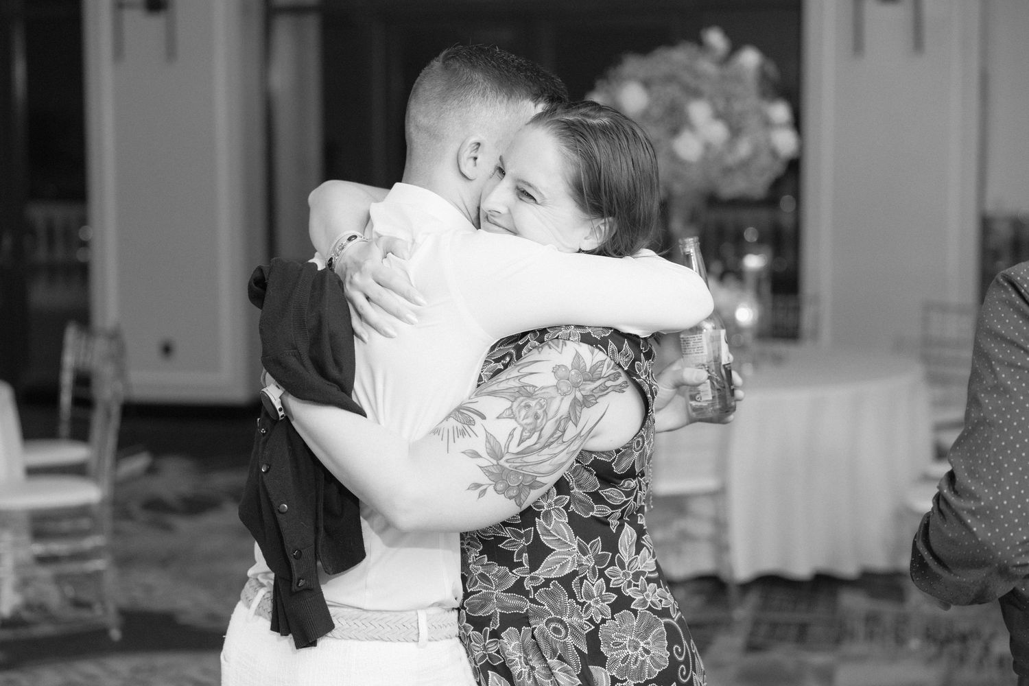 Wedding guests embracing and dancing during an emotional reception moment.