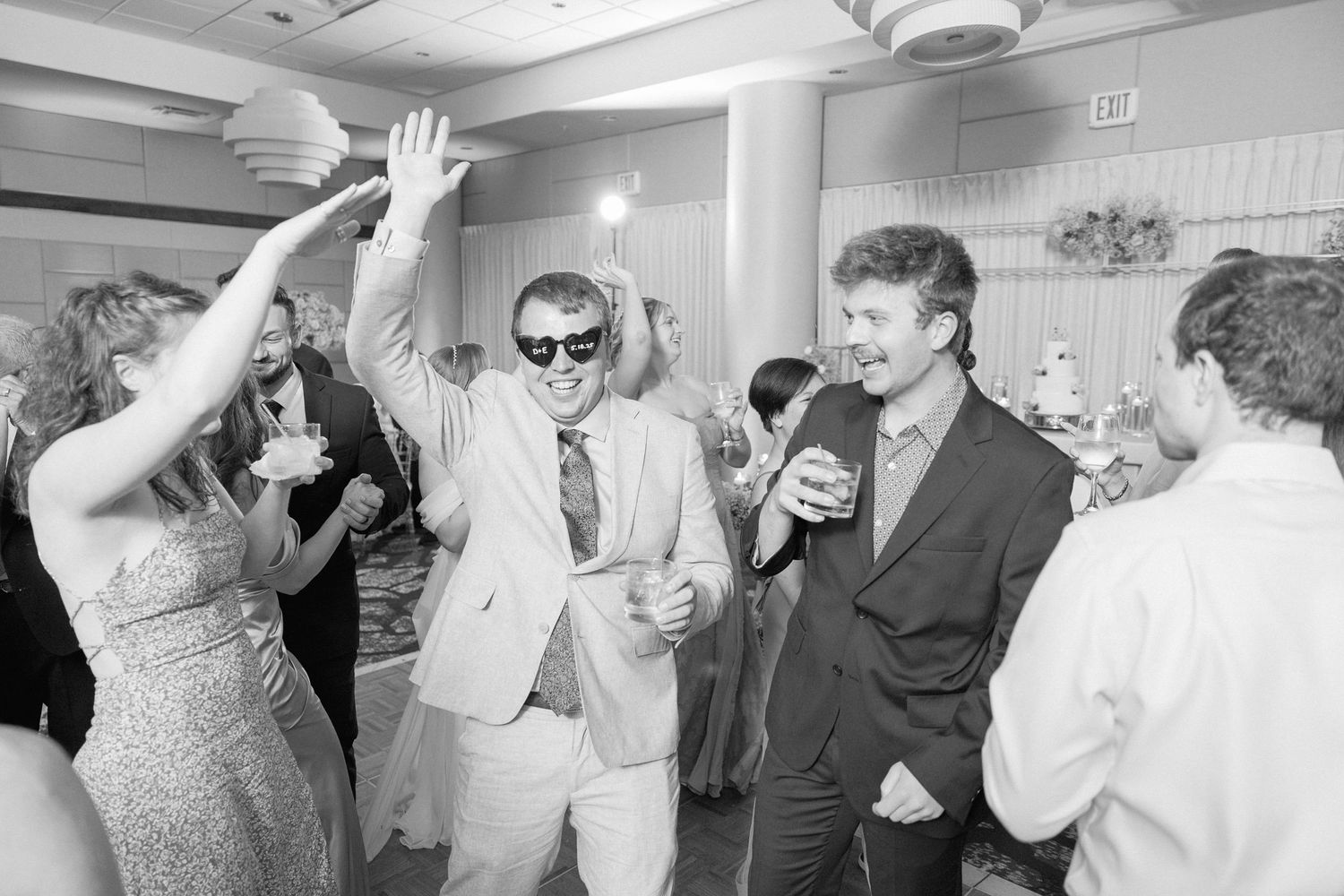 Wedding guests dancing and celebrating together on the dance floor at a reception.