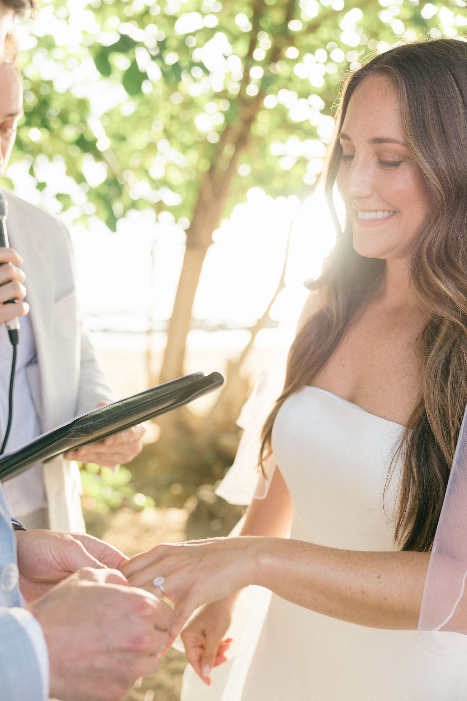 Wedding ceremony participants holding documents during outdoor service.