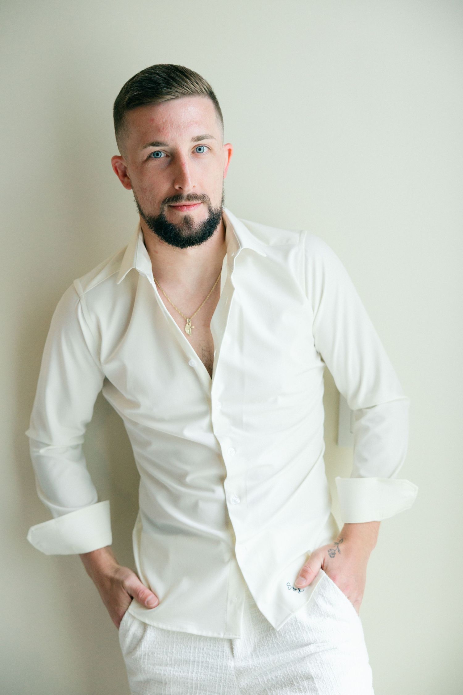 Portrait in classic white button-down shirt against neutral background.