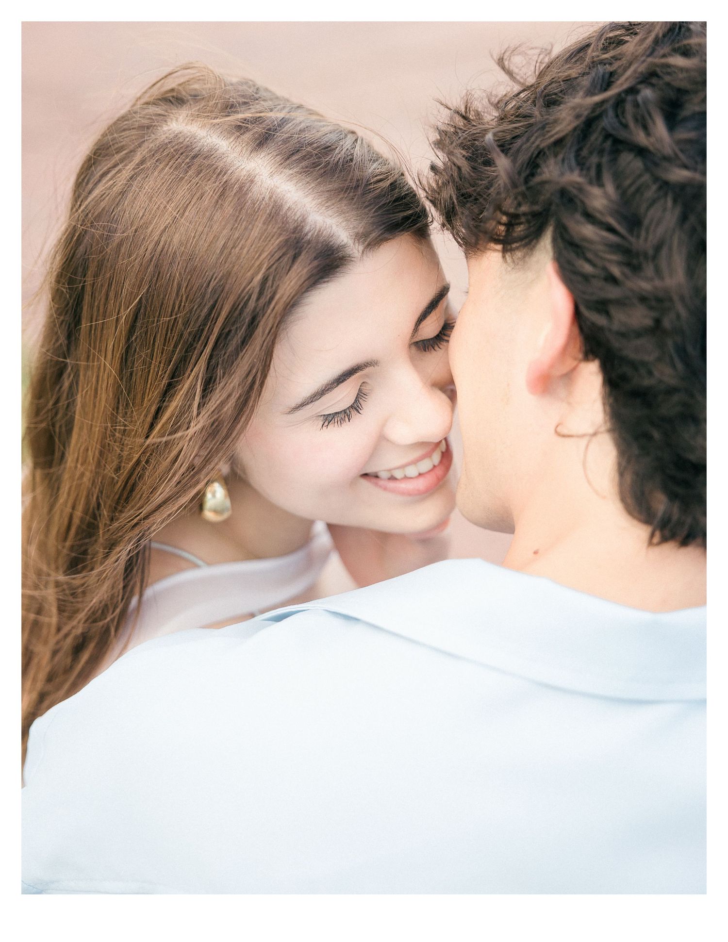 A romantic close-up moment between a couple in soft lighting.