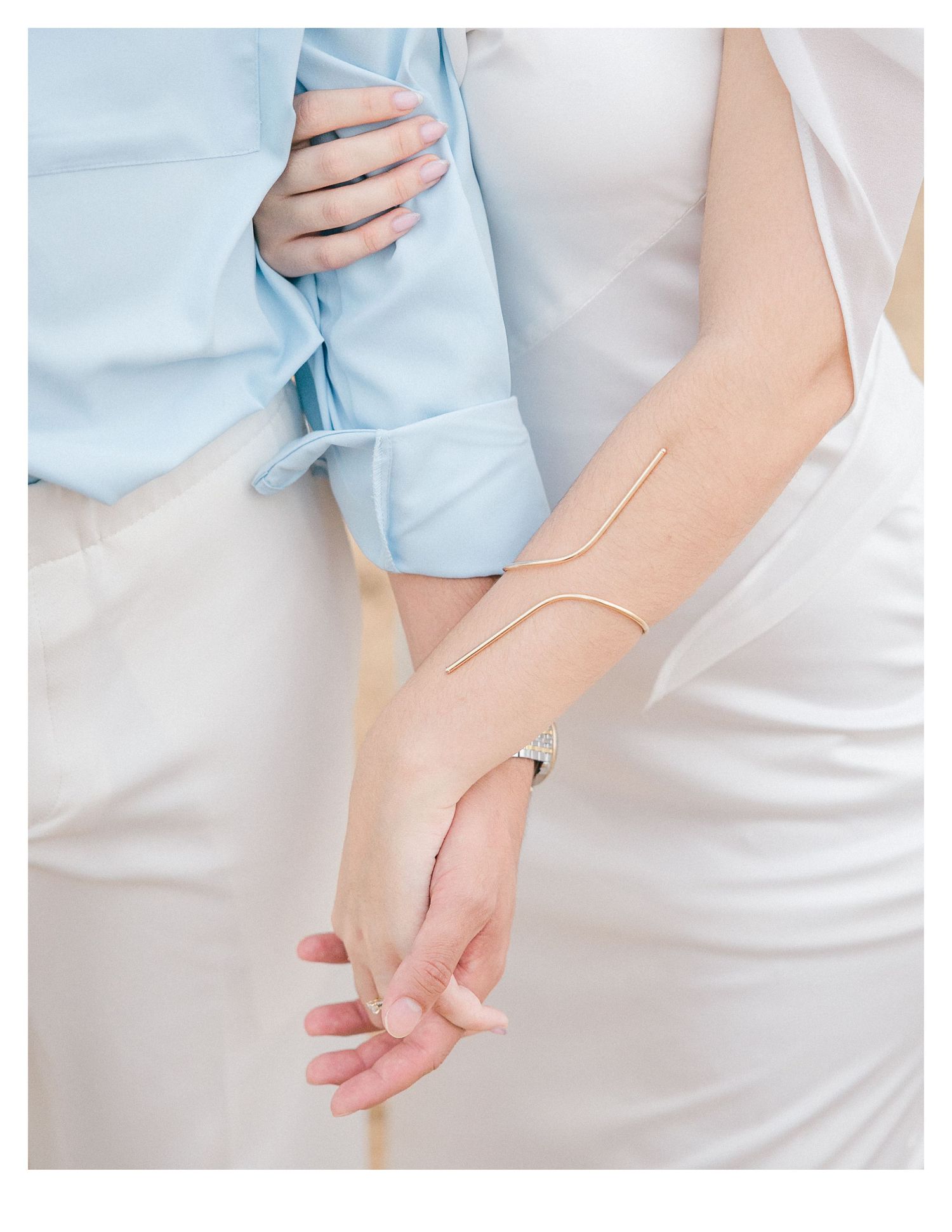 Close-up details of hands and formal attire in soft beachy lighting.