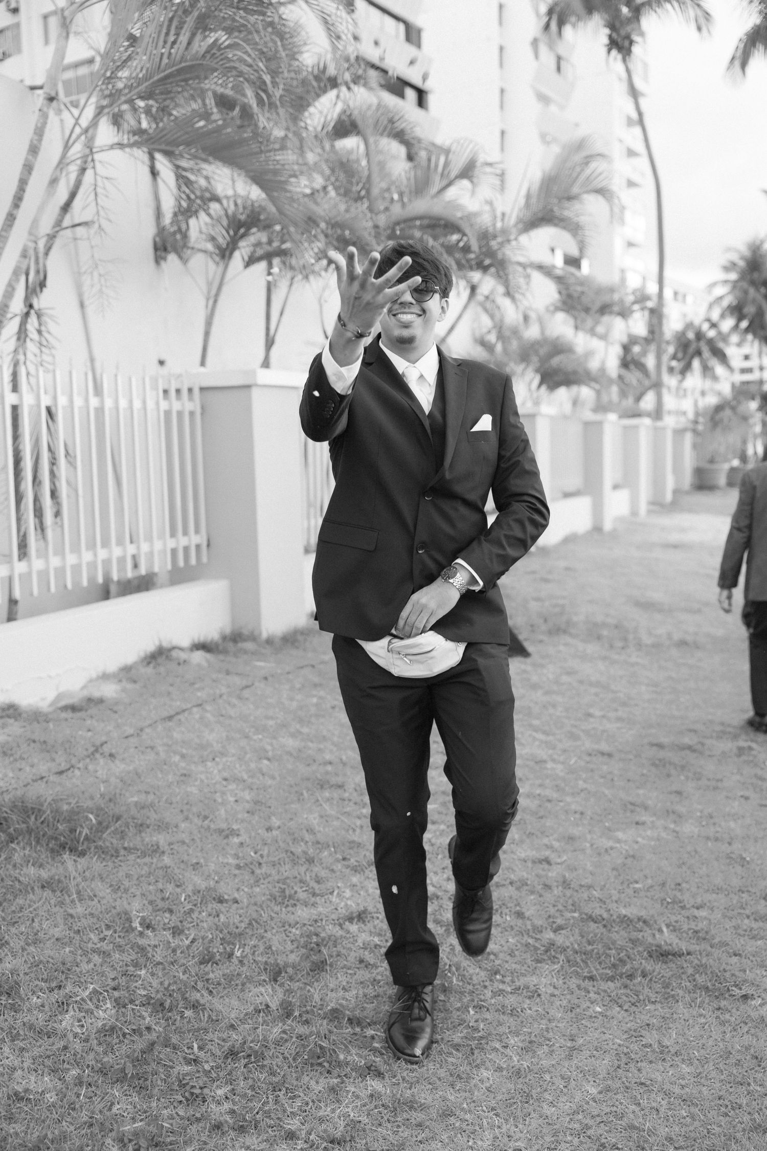 Black and white photo of joyful dancing on a grassy lawn.