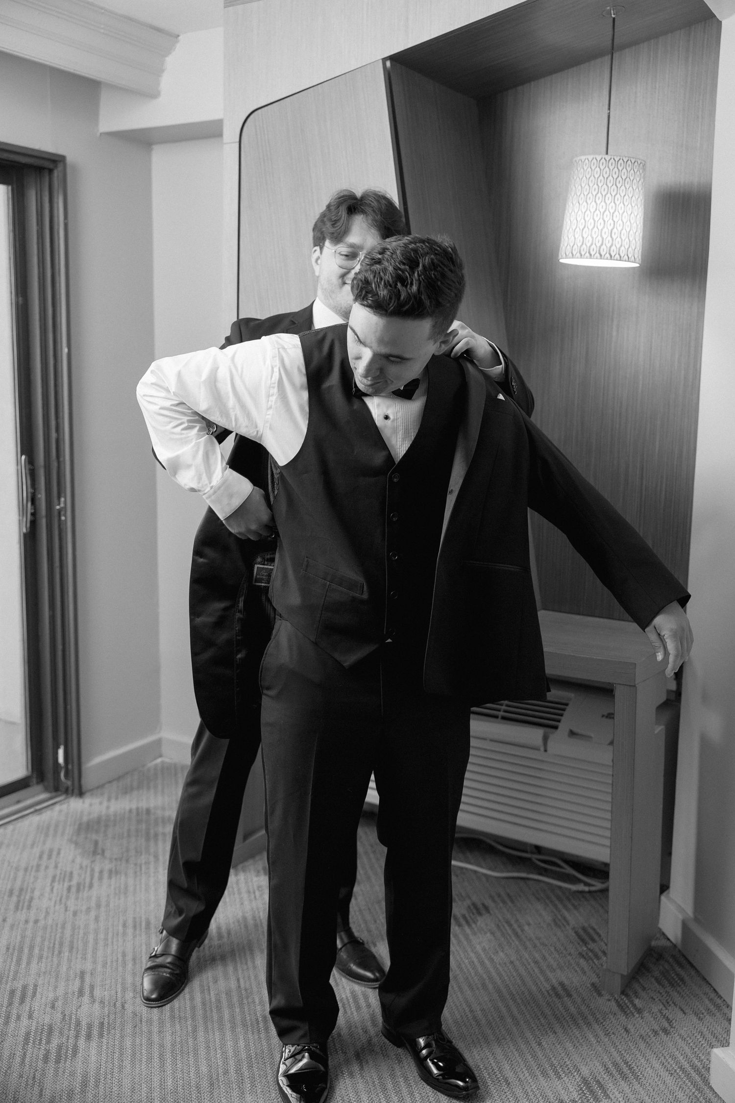 Black and white sequence of formal-dressed figures adjusting shoes and clothing.