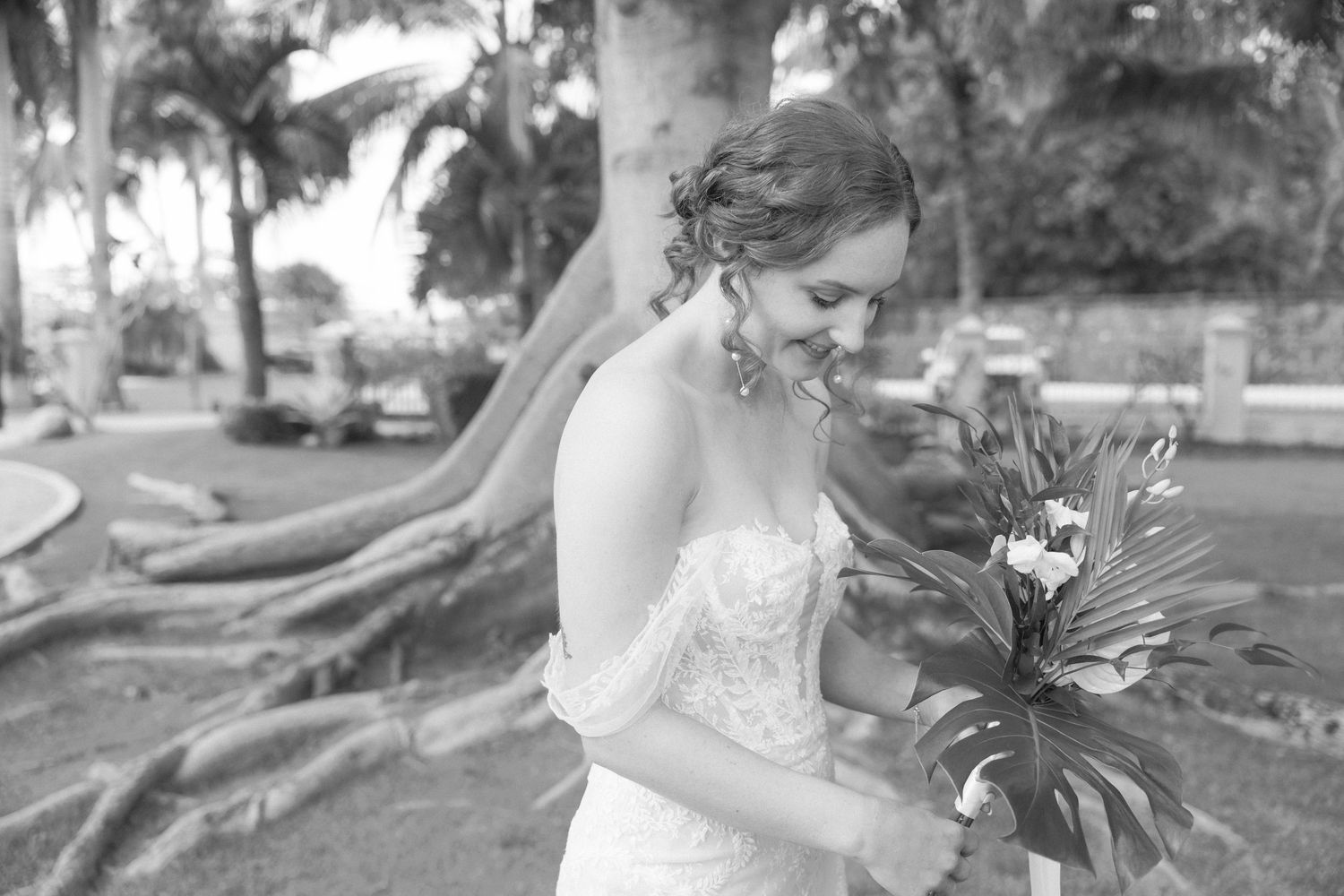 Outdoor wedding photography session with tropical bouquet and formal attire.