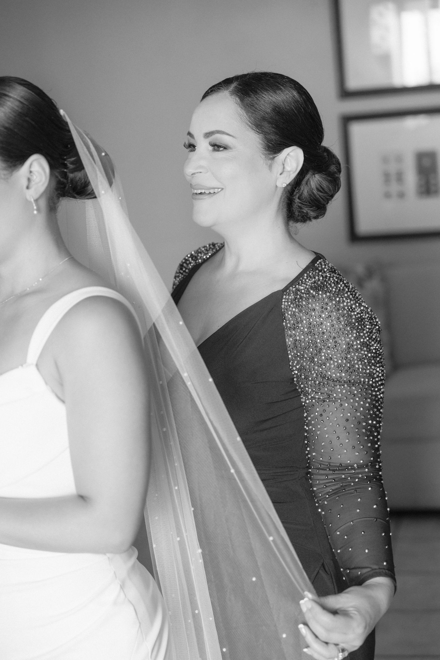 Wedding preparation moments captured in black and white with beaded dress details and veil.