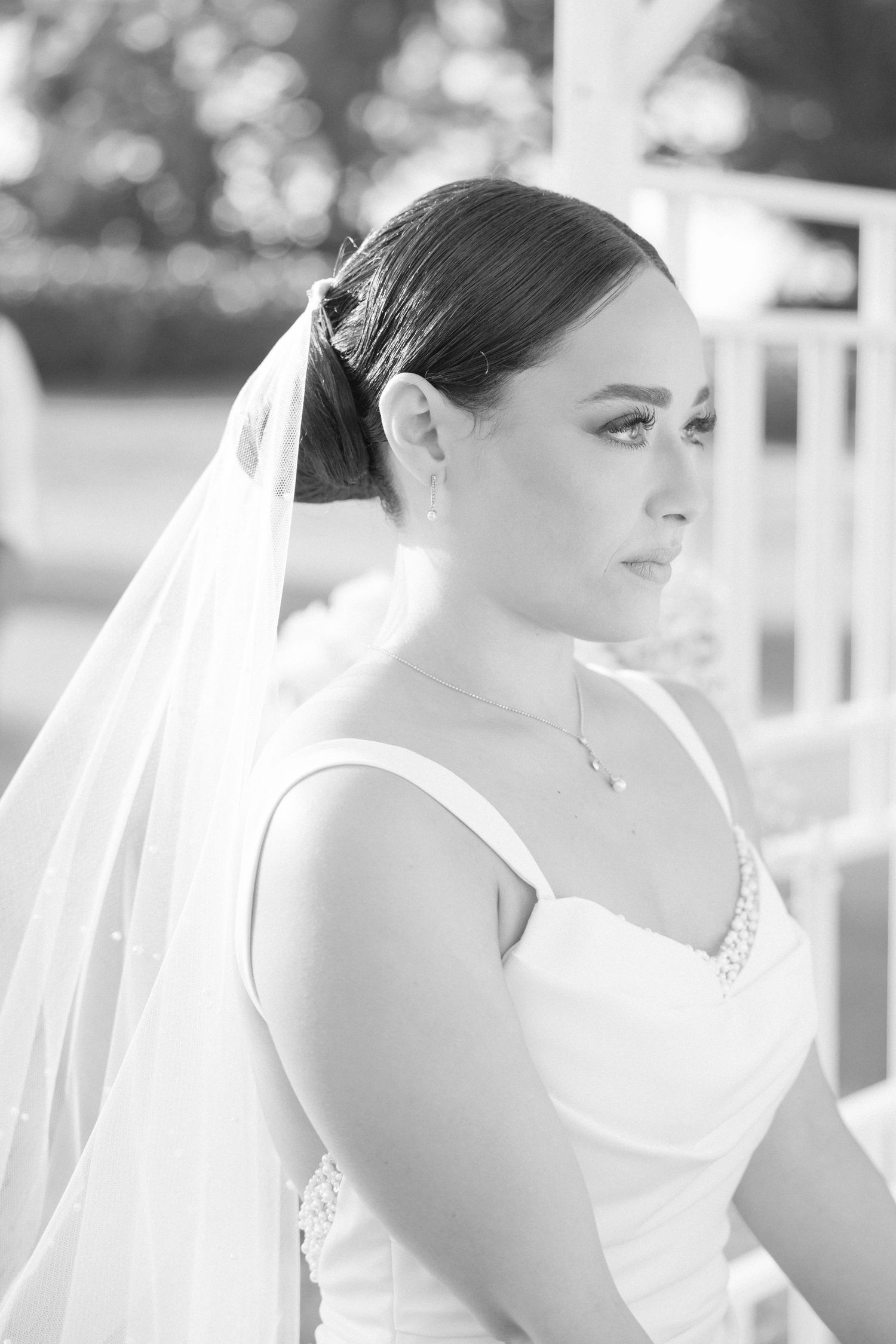 Black and white profile portrait of person in wedding dress with veil.