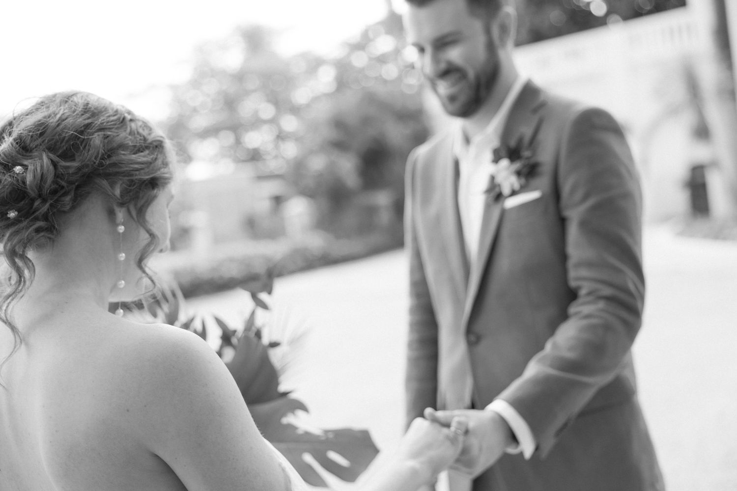 Candid wedding moments photographed in black and white outdoors.