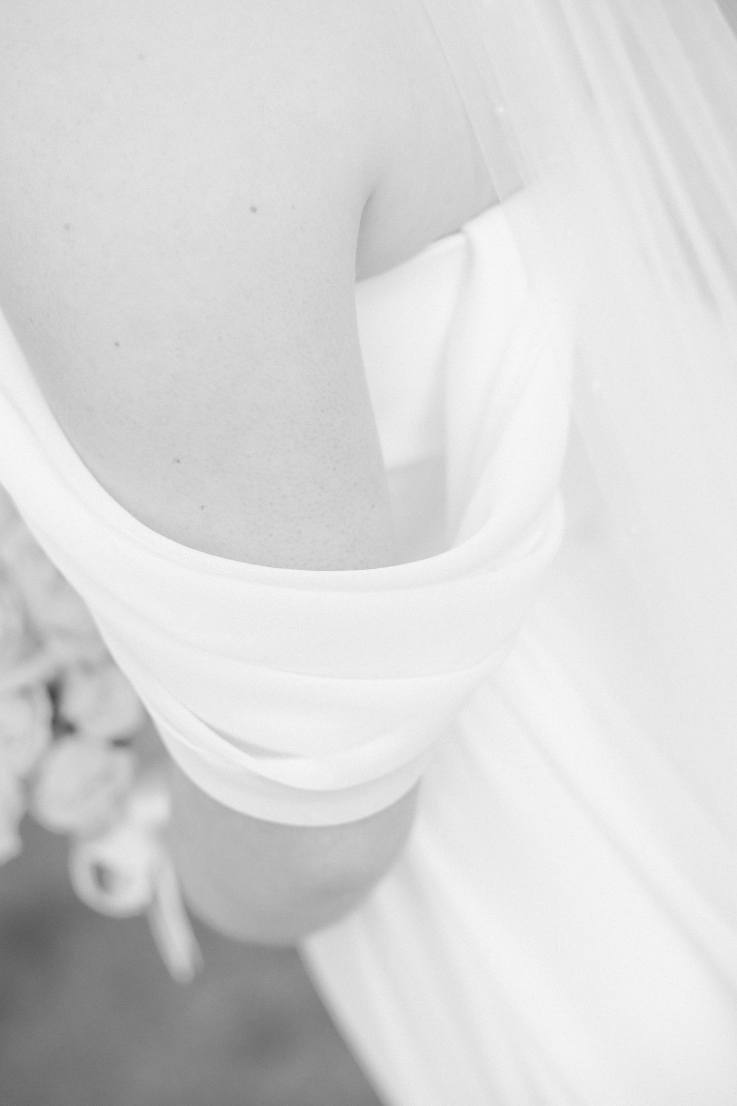 Artistic black and white detail of flowing white wedding dress fabric.