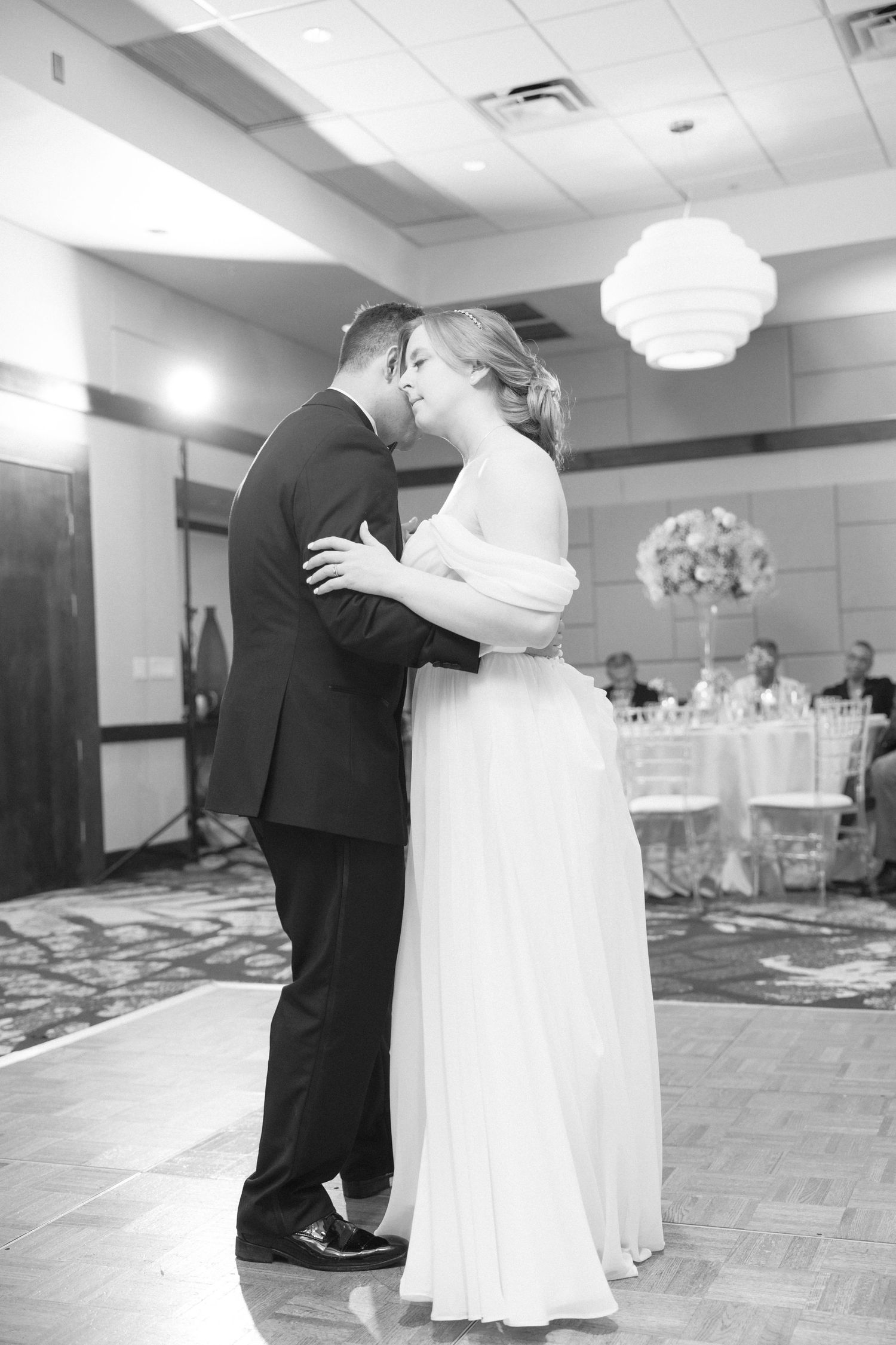 Black and white photos capture intimate wedding dance moments in a reception hall.