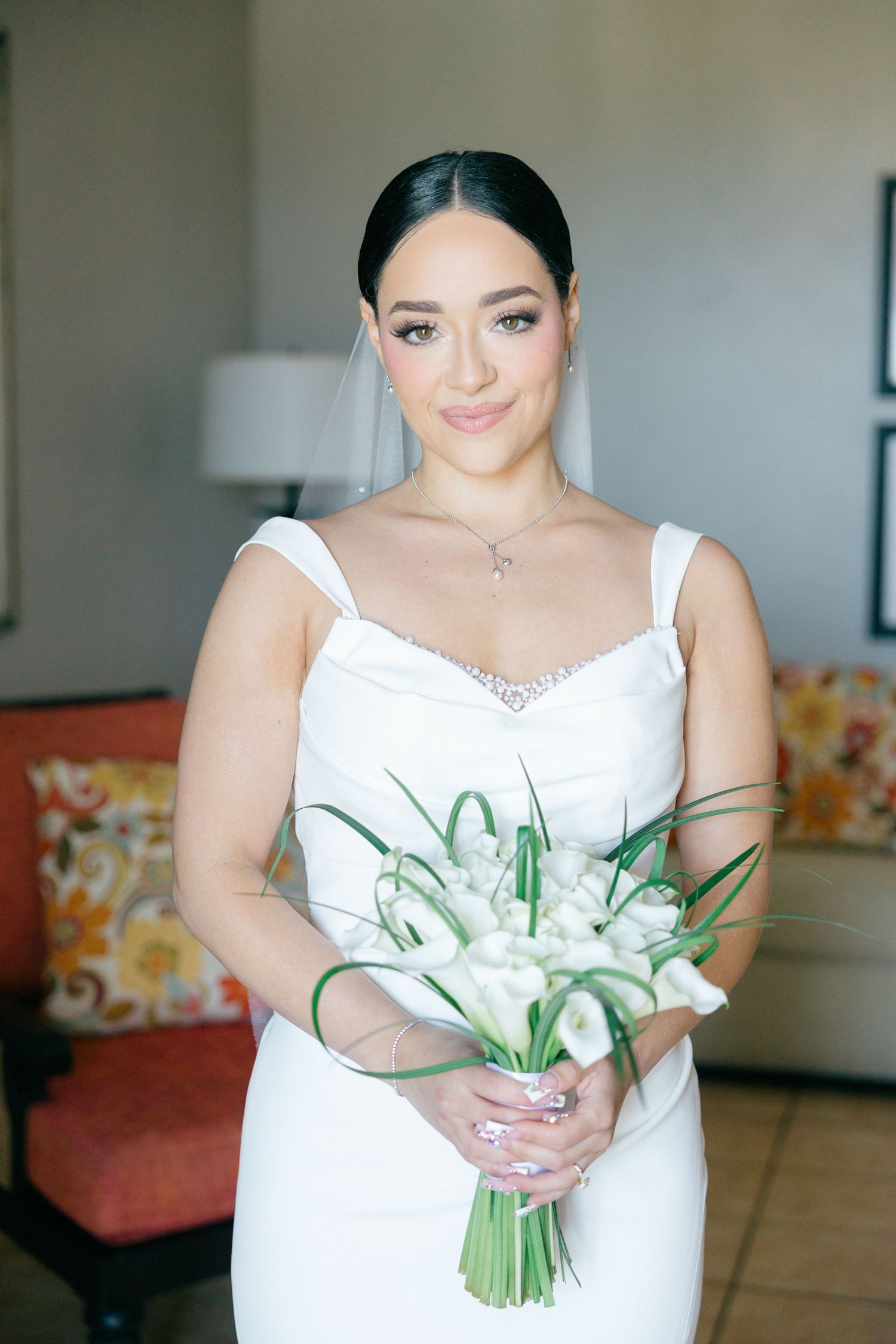 Bride in white wedding dress holding a bouquet of white lilies.