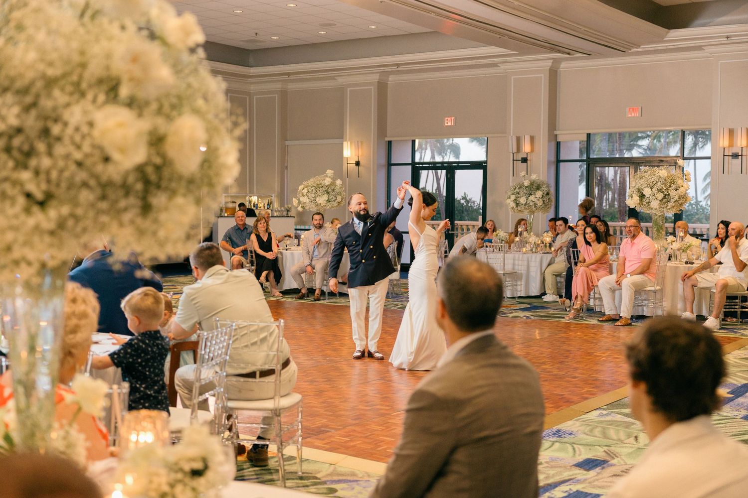 Panoramic view of a wedding reception ballroom with guests dancing and celebrating.