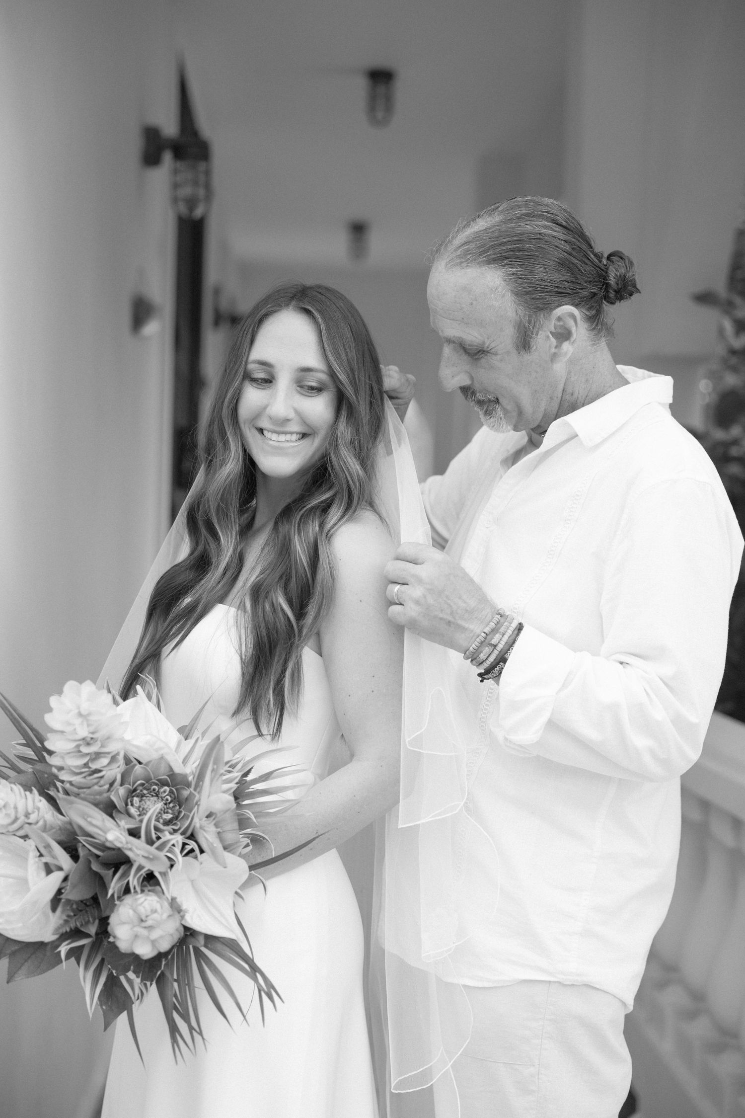 Black and white intimate wedding portrait with tropical bouquet.