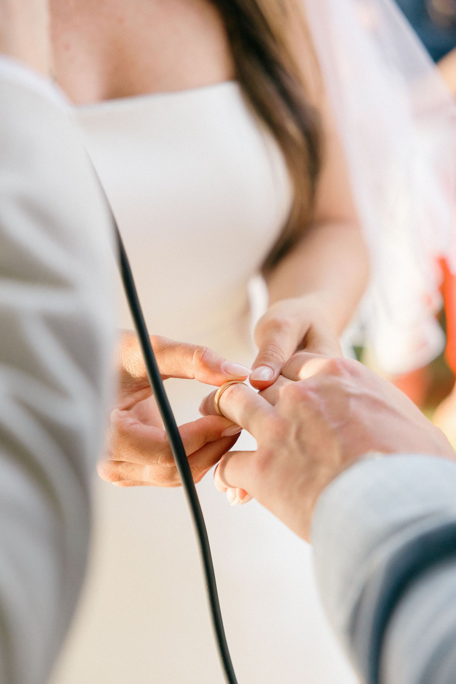 Close-up of hands exchanging rings during wedding ceremony.