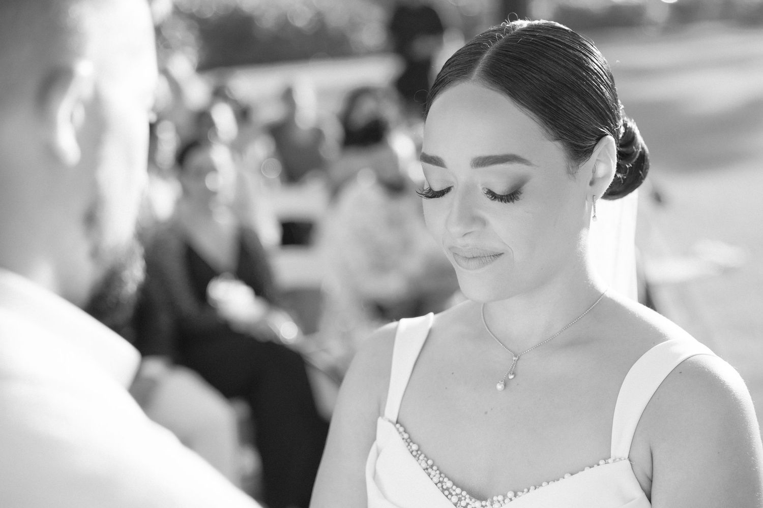 Elegant bride in white dress during outdoor wedding ceremony.