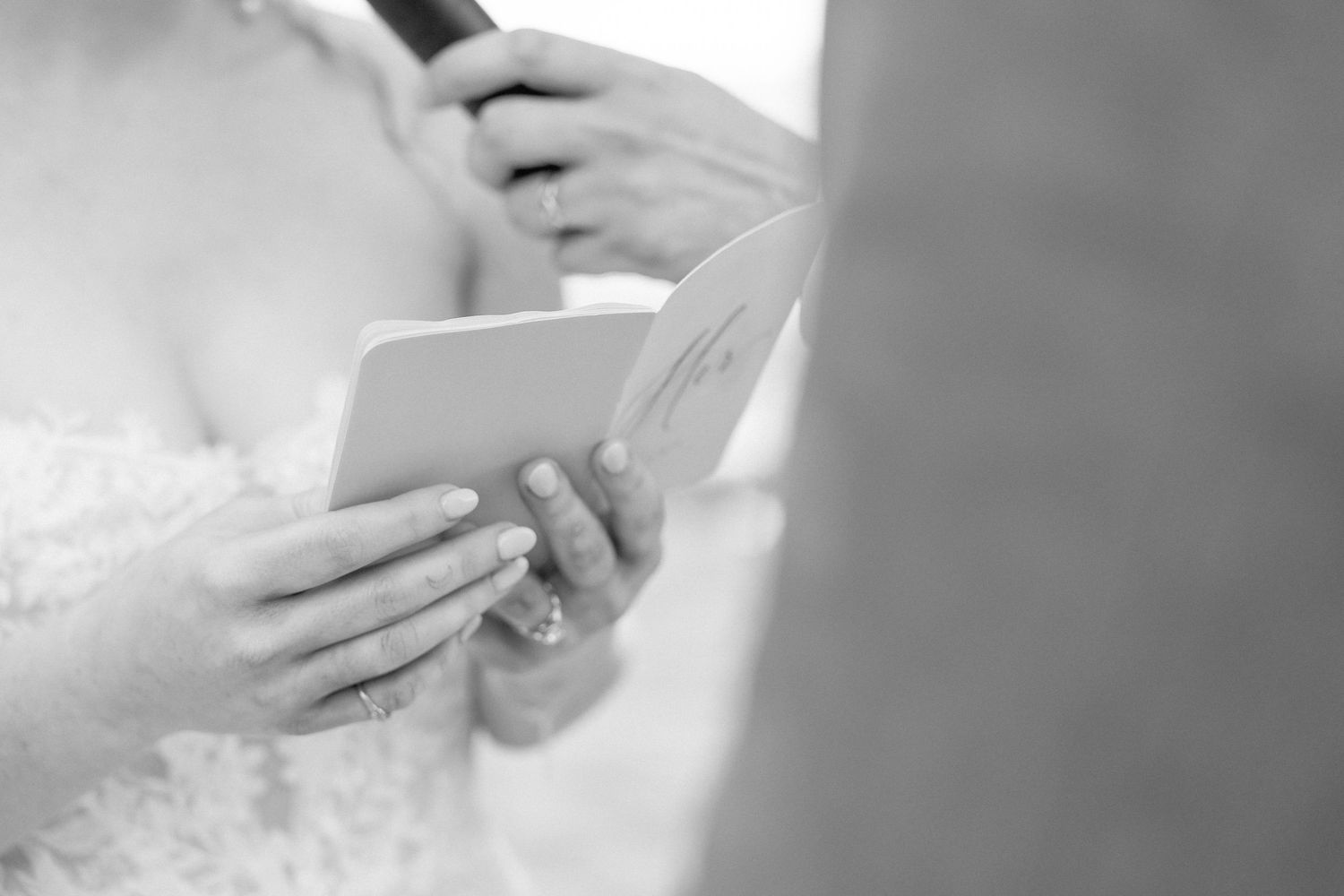Intimate moment captured during wedding ceremony with hands clasped together.