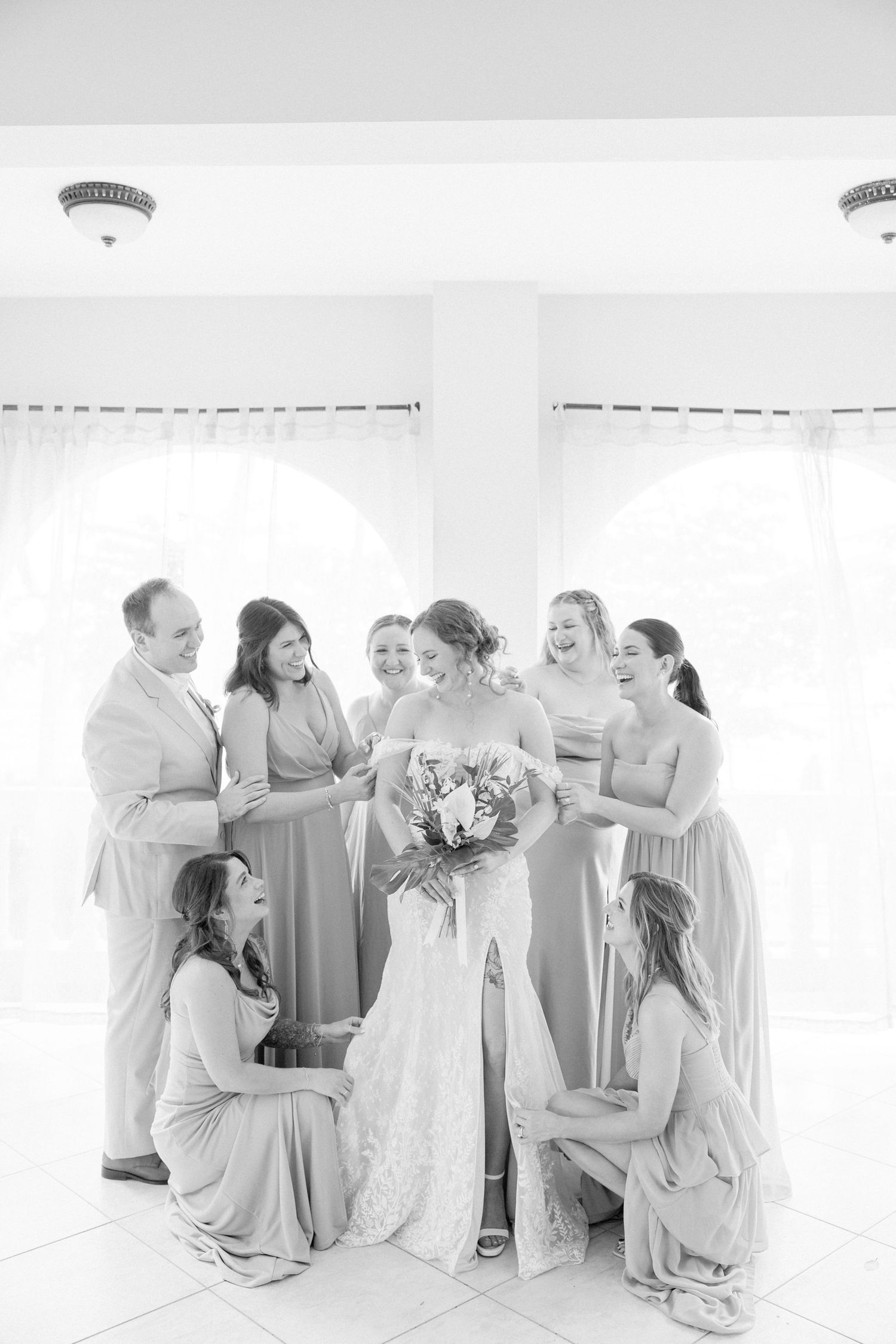 Bridesmaids in soft gray dresses share emotional moments during a wedding celebration.