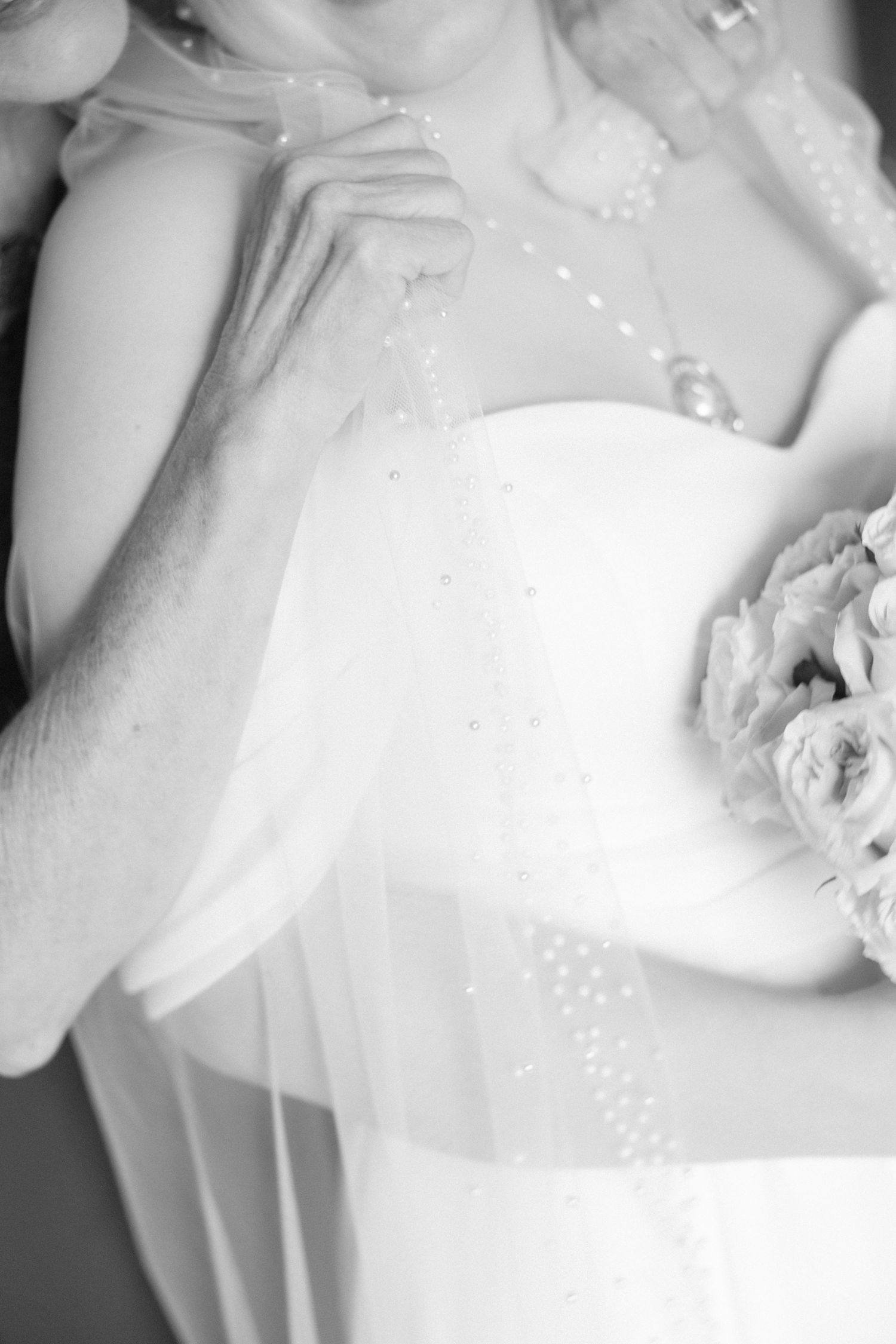Close-up details of white wedding dress fabric and embellishments in black and white.