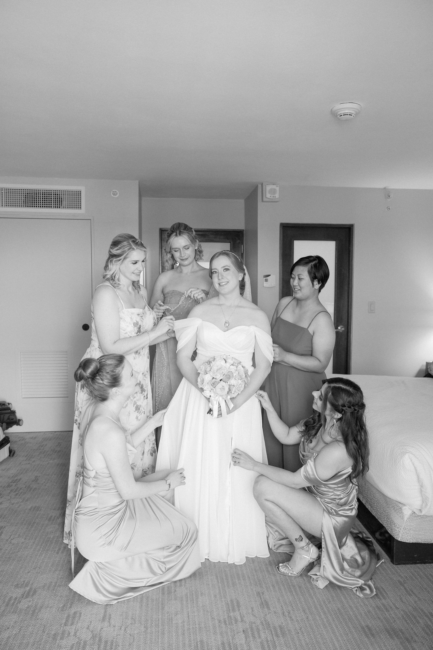 Black and white sequence showing wedding preparation moments on the floor of a hotel room.