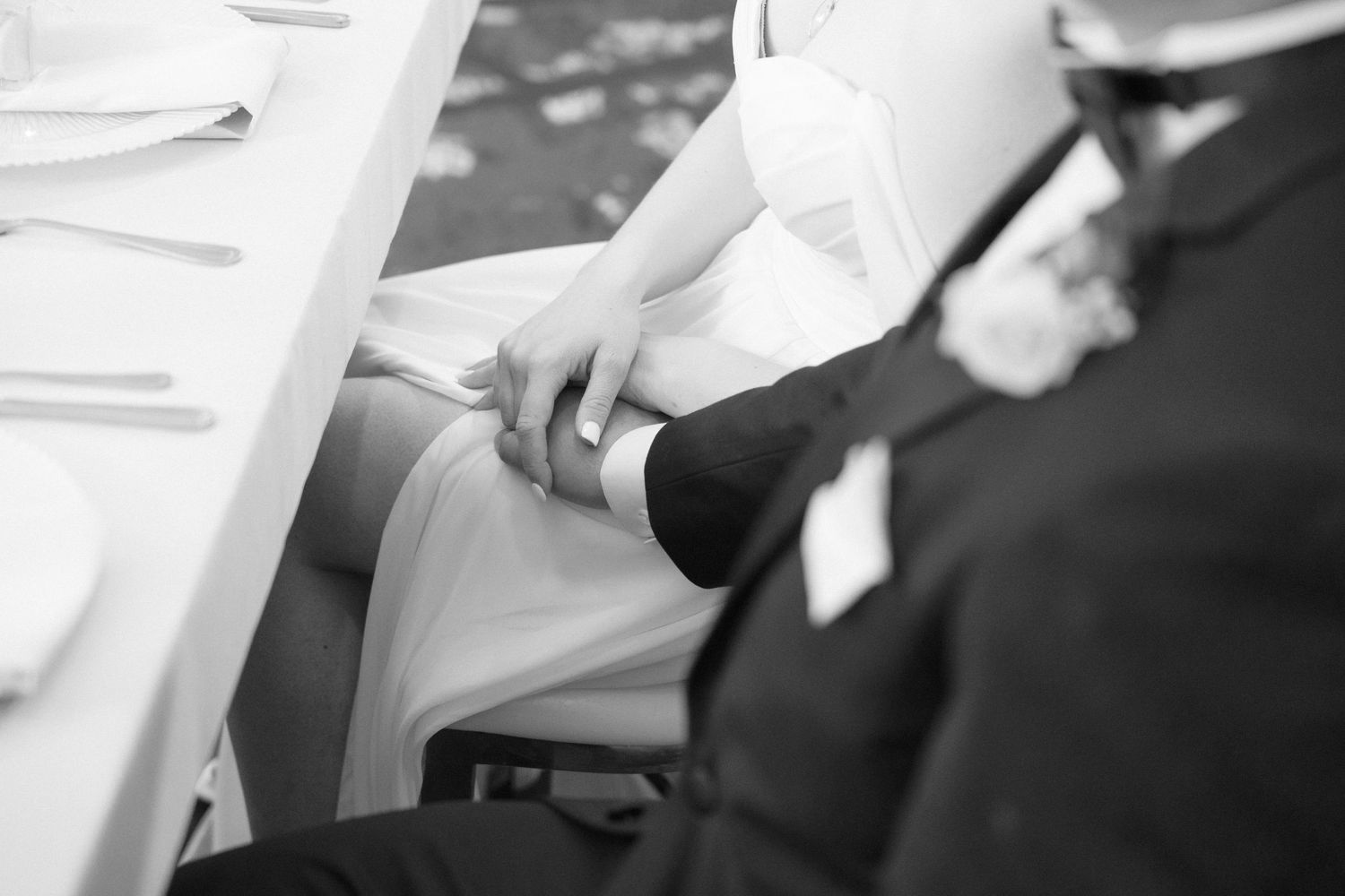 Black and white candid shot of wedding reception guests at their tables.