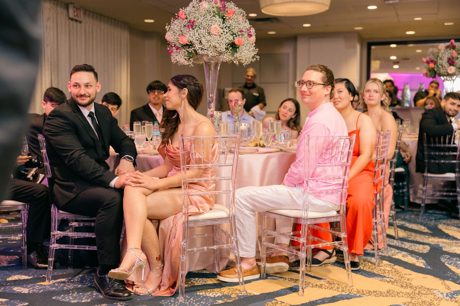 Wedding reception tables set with crystal centerpieces and pink floral decorations.