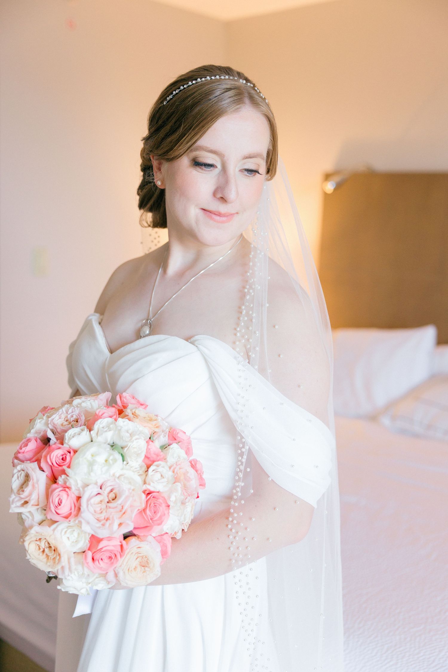 Soft-lit bridal portrait with pink and white rose bouquet.