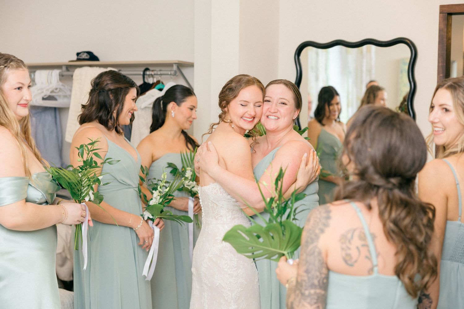 Emotional pre-wedding moment shared between bridal party members in mint green dresses.