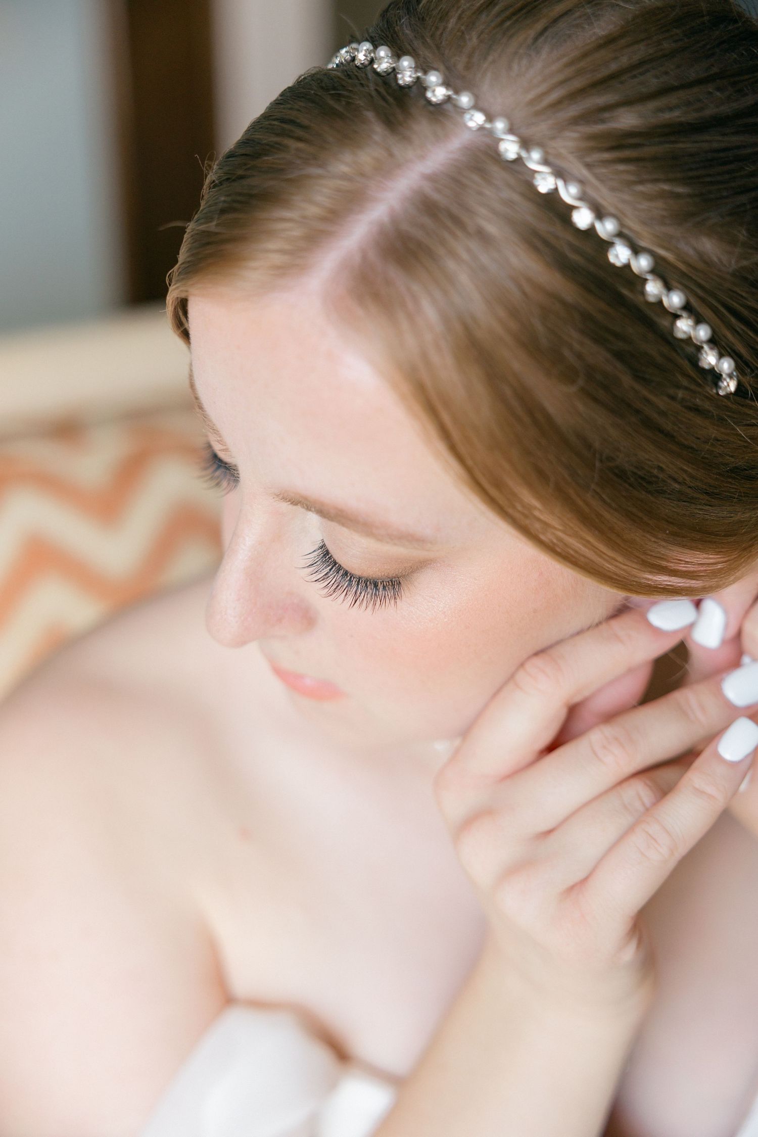 Delicate pearl headpiece adorns an elegant bridal hairstyle with soft makeup.