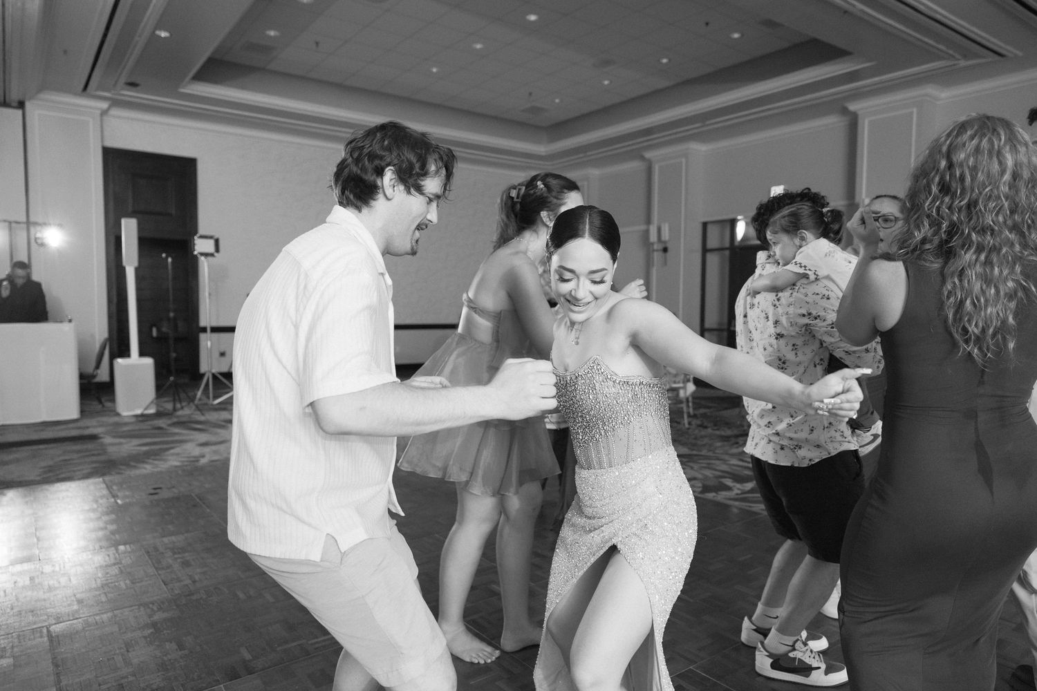 People dancing and celebrating at a formal wedding reception party.