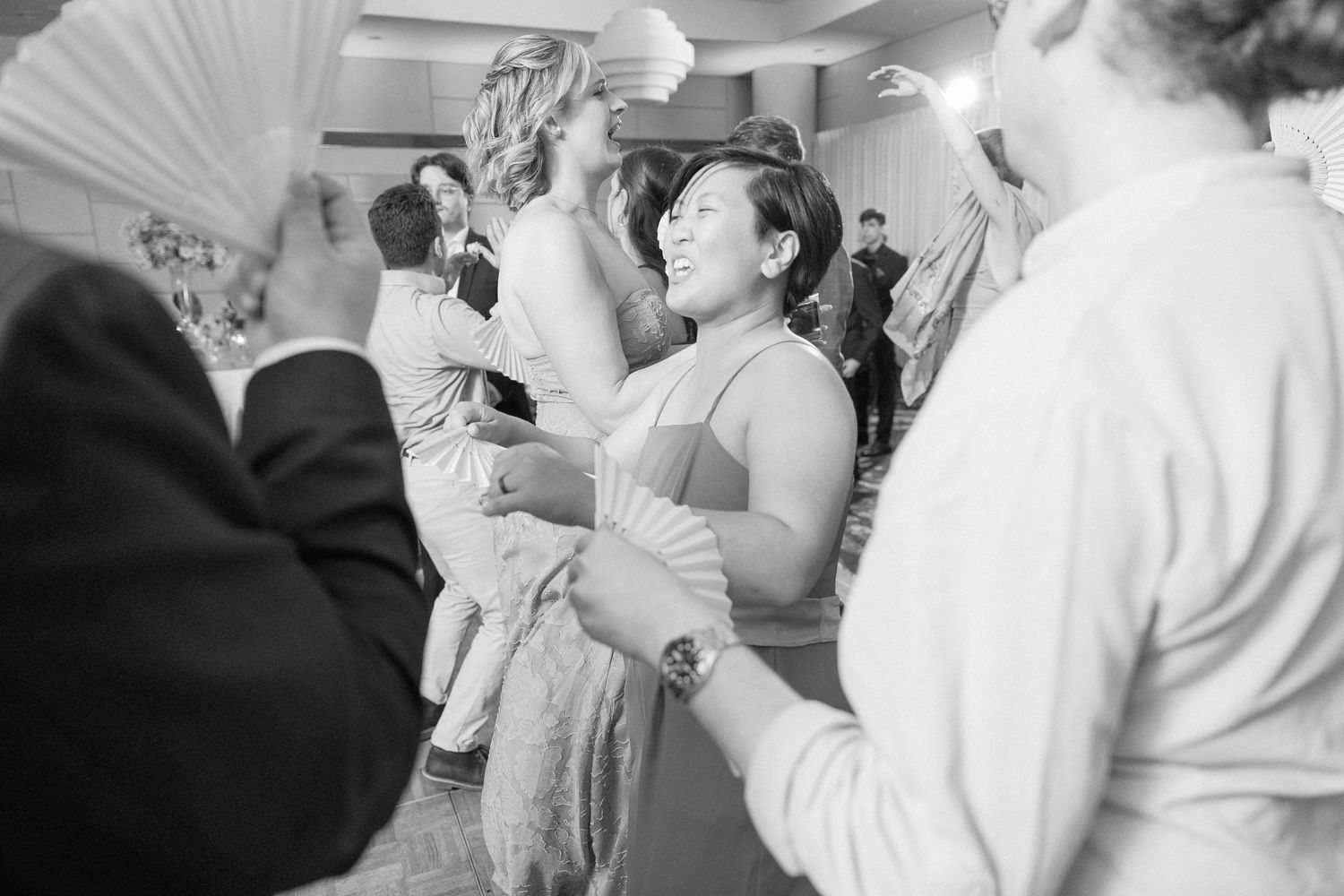 Wedding guests dancing and enjoying themselves at an indoor reception venue.