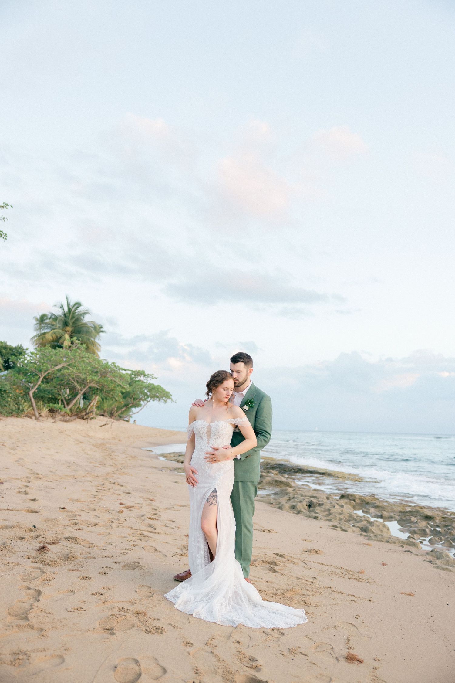 Romantic beach wedding photoshoot with couple walking along shoreline at sunset.